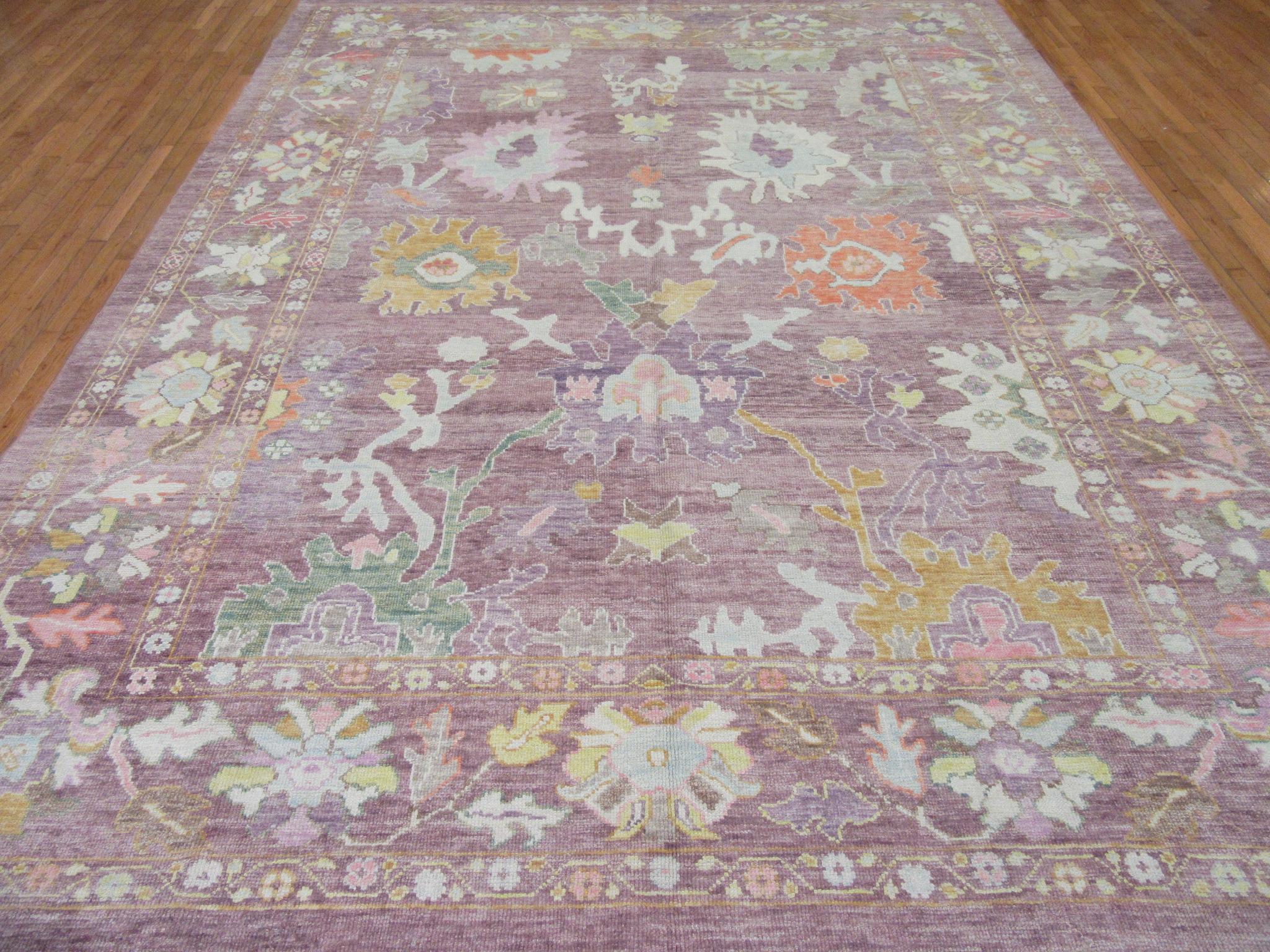 This is a new hand knotted Oushak design rug from Turkey. It is made with wool pile and wool on a wool foundation in soft colorful tones. Its transitional all-over pattern would make it a perfect choice for any room. The rug measures 9' 7'' x 12'