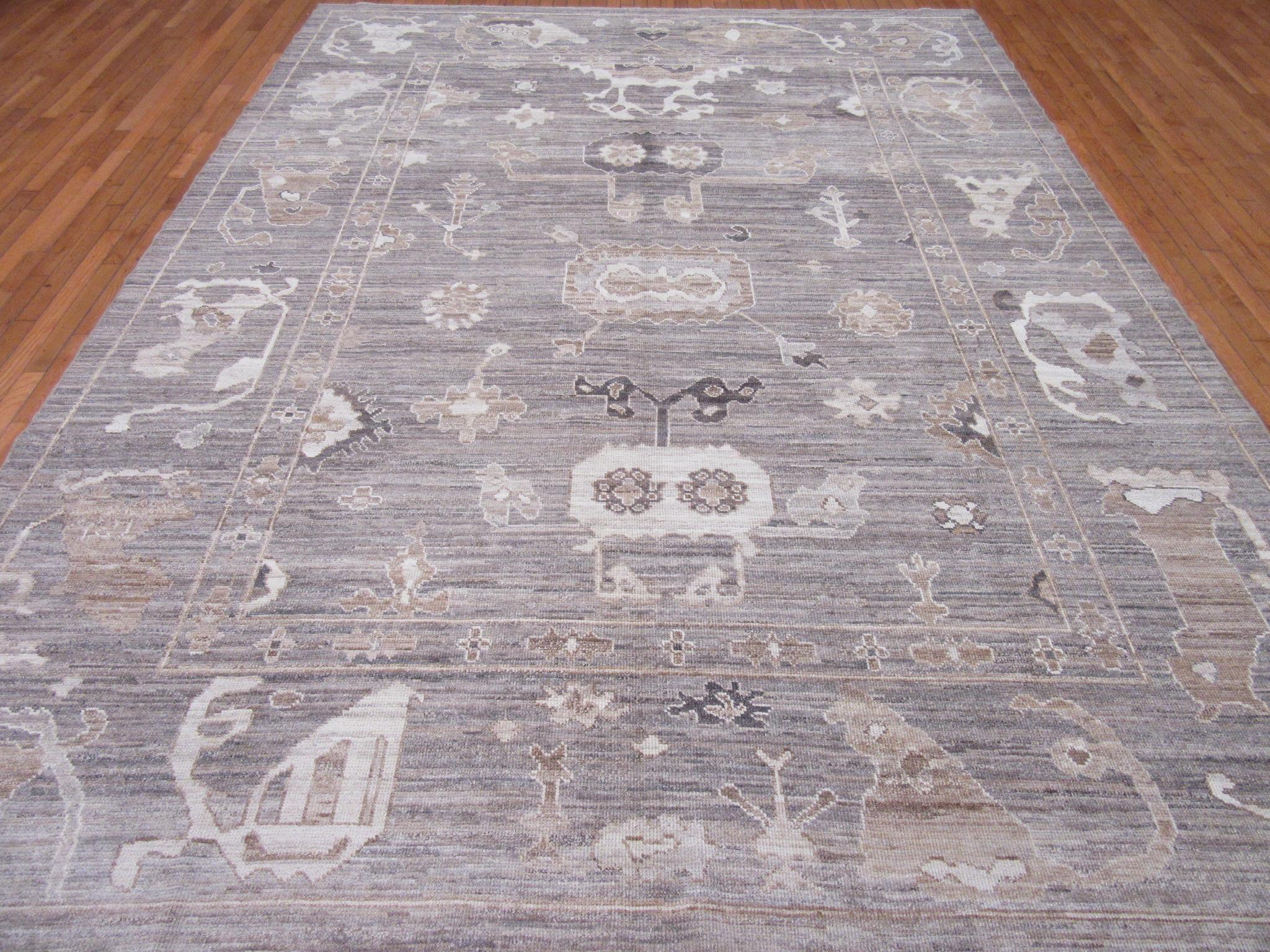 This is a new hand knotted Oushak design rug from Turkey. It is made with wool pile and wool on a wool foundation in gray tones. Its transitional all over pattern would make it a perfect choice for any room. The rug measures 9' x 12' 3''.