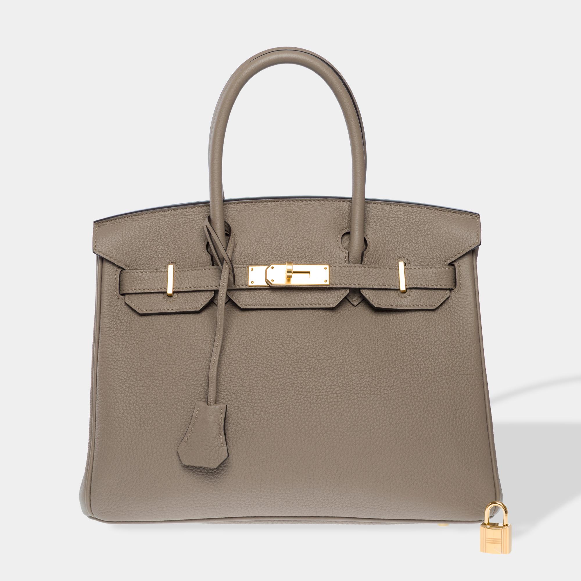 Excepcional bolso Hermes Birkin 30 de piel de becerro Gris Asphalte Togo , ribete metálico dorado, doble asa de piel gris para llevar en la mano

Cierre con solapa
Forro interior de piel gris, un bolsillo con cremallera, un bolsillo de parche
Firma: