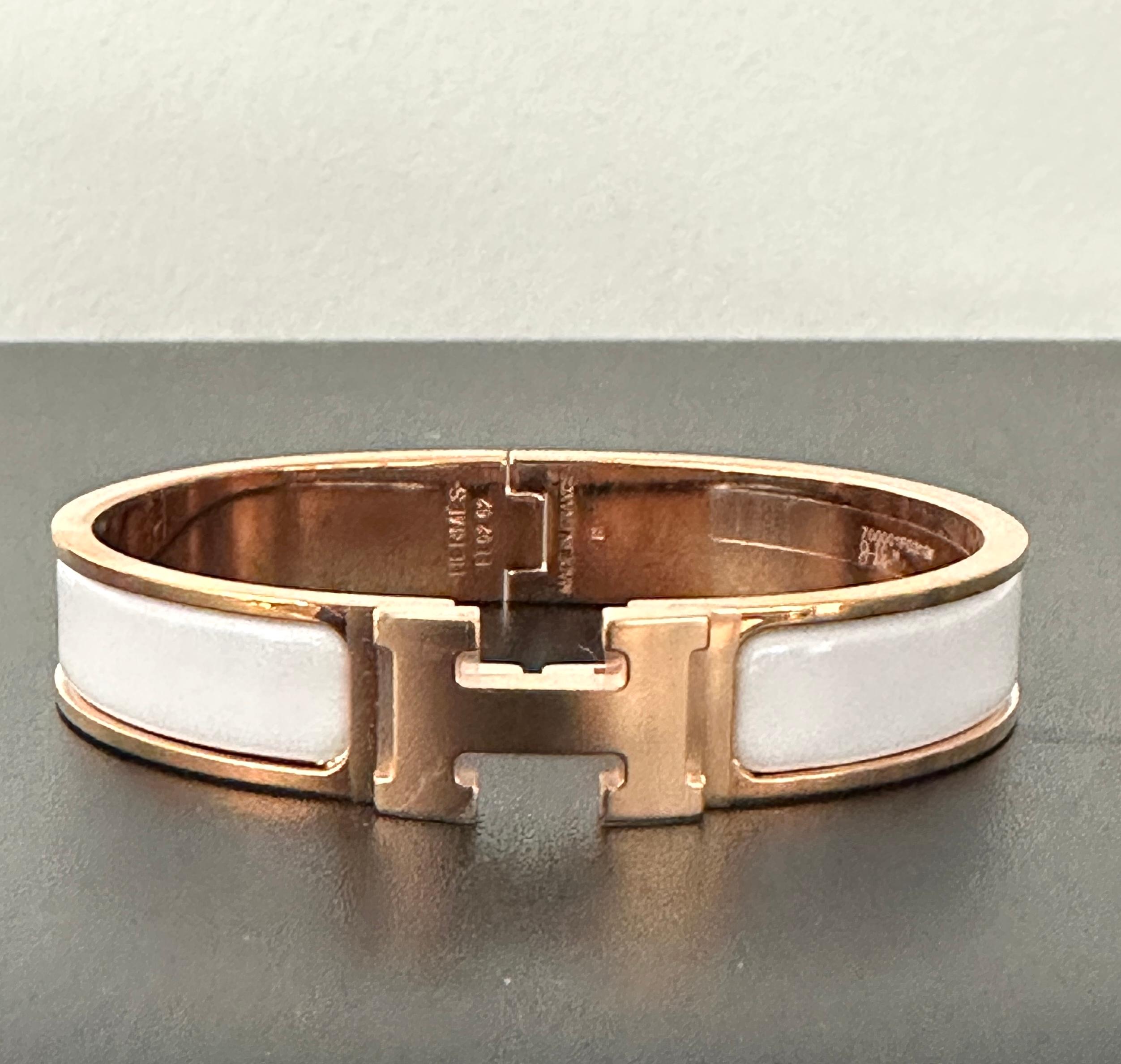 The Clic Clac H GM
GM SIZE 
Hermes bracelet in Rose Gold Plated 
Color is White
GM size, for the larger hand 
Circumference: 7.5