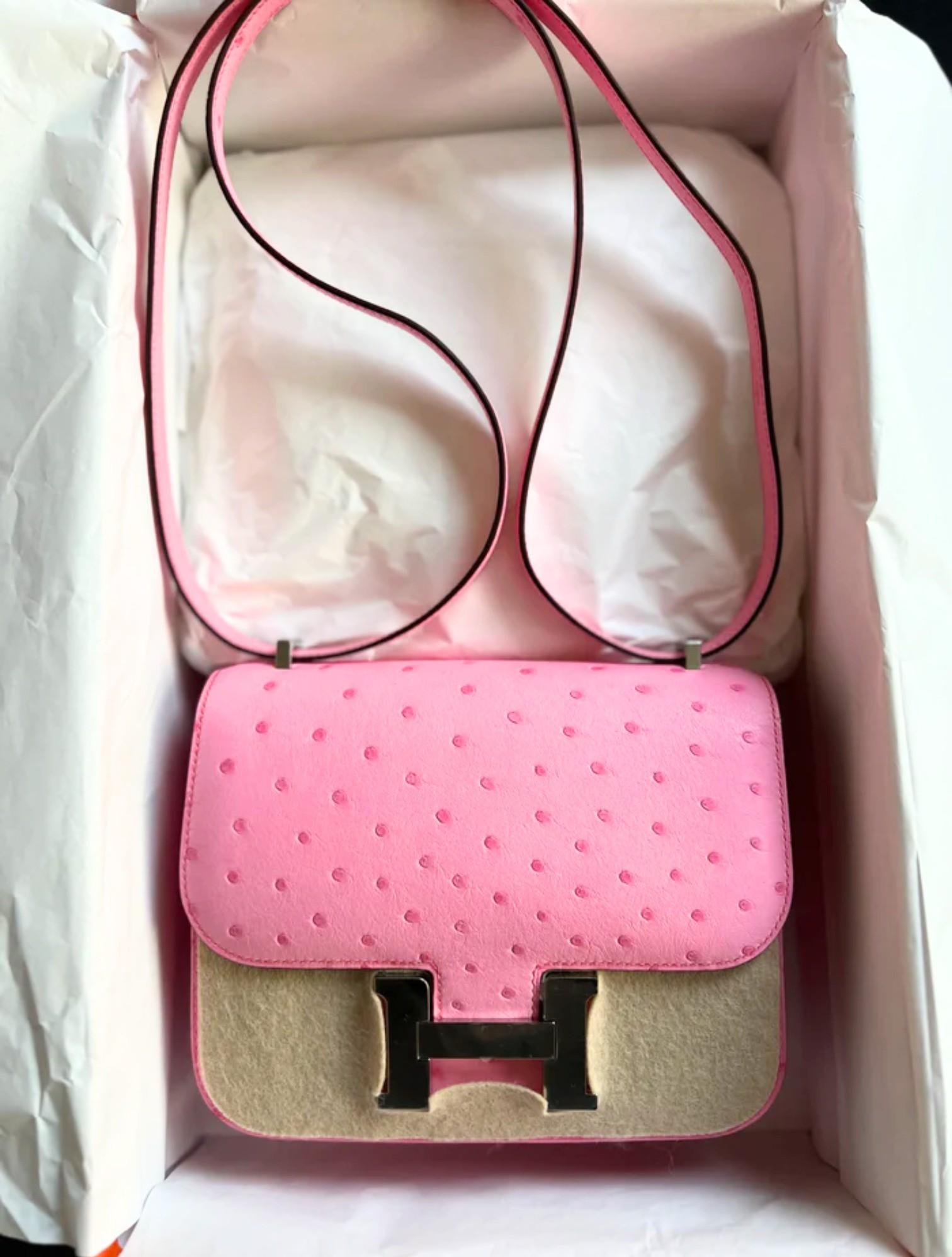 Offrez-vous la rare et luxueuse Hermès Constance III Mini, fabriquée avec expertise à partir du cuir d'autruche le plus fin, dans une superbe teinte Rose Bubblegum. Cette pièce unique présente une forme rectangulaire distinctive et un fermoir