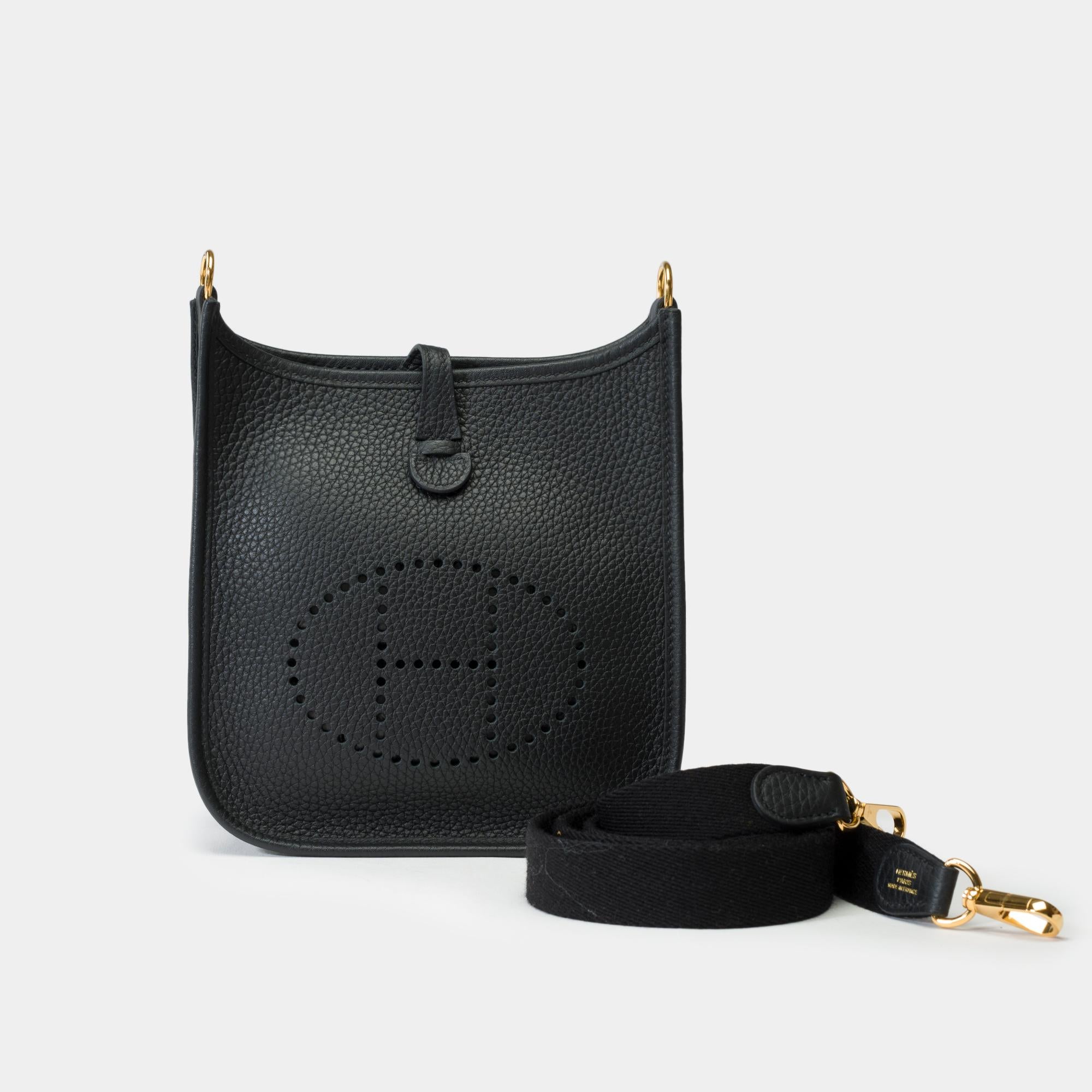 Splendid​ ​Hermes​ ​Evelyne​ ​16​ ​TPM​ ​shoulder​ ​bag​ ​in​ ​black​ ​Taurillon​ ​leather,​ ​with​ ​gold-tone​ ​metal​ ​hardware,​ ​and​ ​a​ ​removable​ ​black​ ​canvas​ ​strap​ ​for​ ​shoulder​ ​or​ ​crossbody​ ​wear

Snap​ ​button​ ​closure​ ​on​