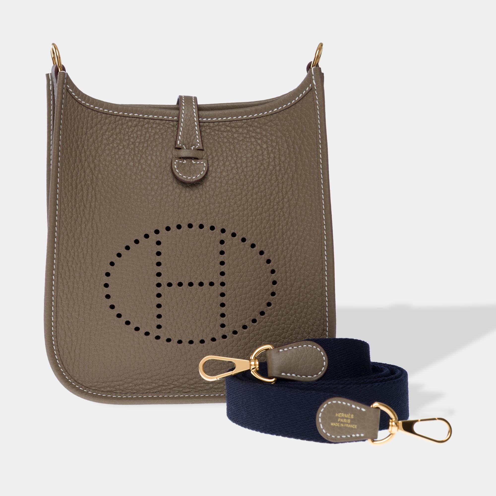 Splendid​ ​Hermes​ ​Evelyne​ ​16​ ​TPM​ ​Amazone​ ​shoulder​ ​bag​ ​in​ ​Etoupe​ ​Taurillon​ ​Clémence​ ​leather​ ​with​ ​white​ ​stitching,​ ​gold​ ​metal​ ​hardware,​ ​a​ ​removable​ ​shoulder​ ​strap​ ​in​ ​blue​ ​indigo​ ​canvas​ ​and​ ​Etoupe,​