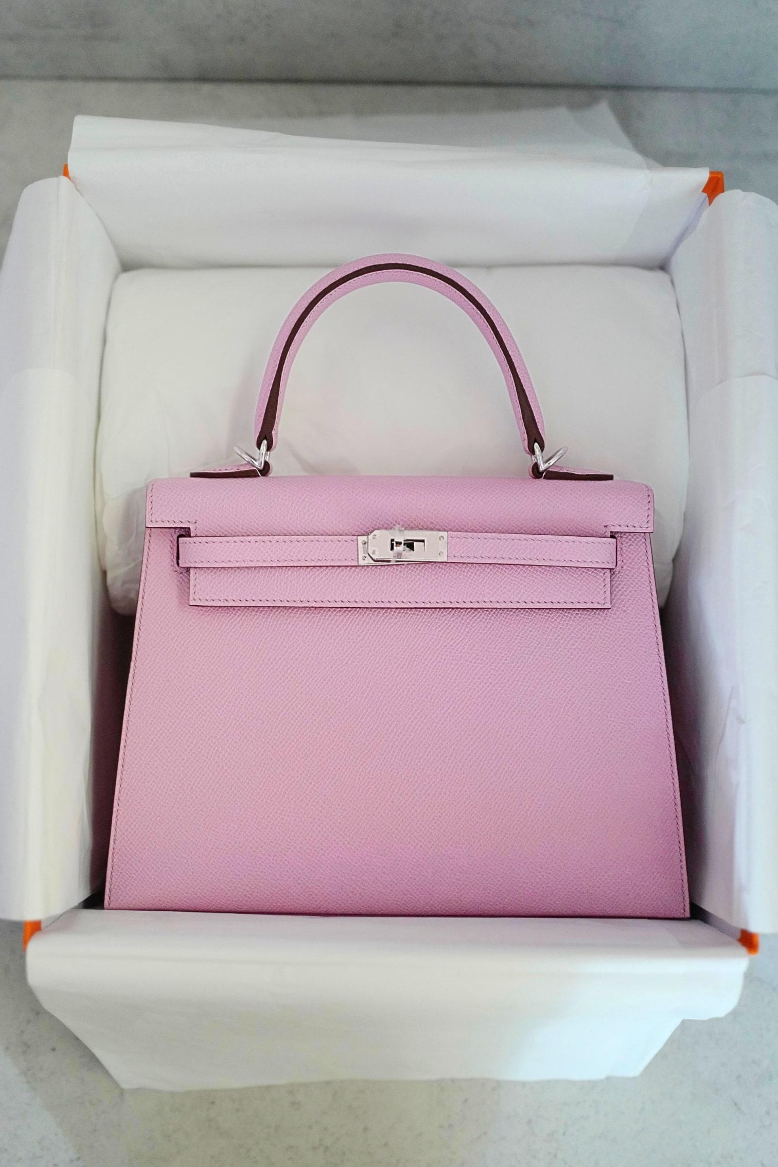 The Hermès Kelly 25 Sellier in Mauve Sylvestre Epsom with Palladium Hardware is a masterpiece of elegance and refined craftsmanship. Featuring the structured Sellier construction, this bag presents sharp lines and a timeless silhouette, beautifully
