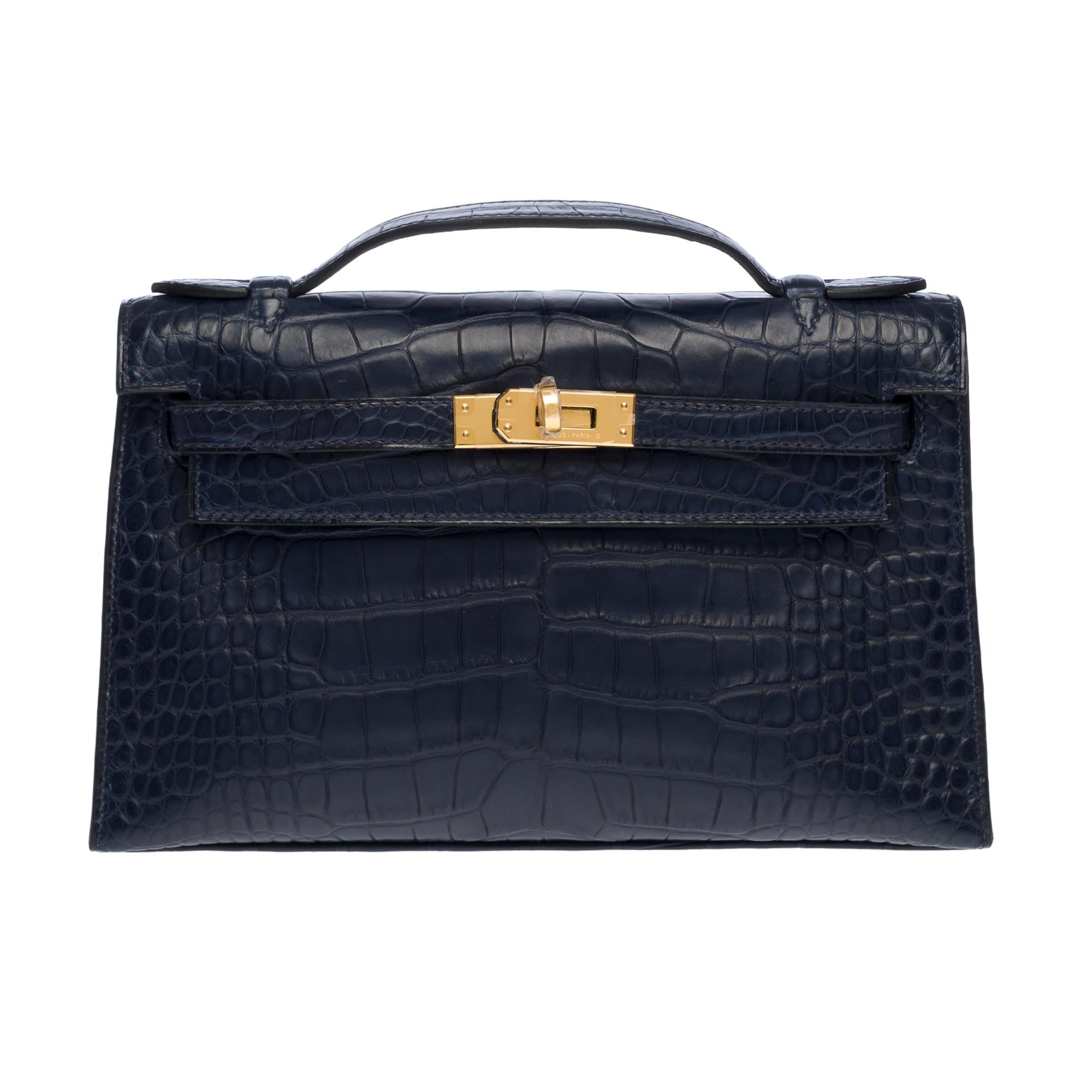 Rare & Exceptional Pochette Hermès Kelly Clutch in Blue Indigo matte Porosus Crocodile leather, gold-plated metal hardware, Blue crocodile handle for a hand carry

Flap closure
Inner lining in blue leather, one patch pocket
Signature: 