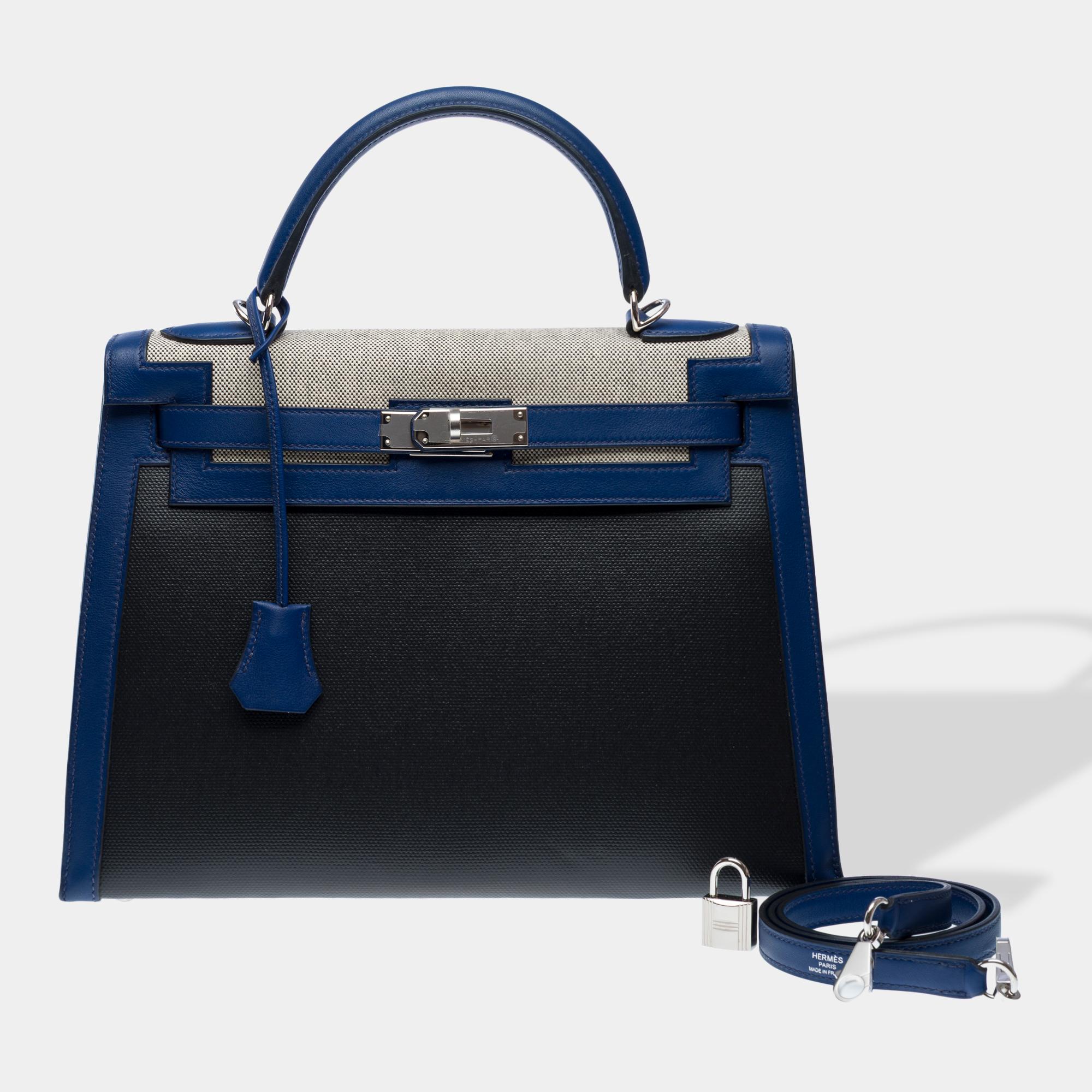 Exquisite​ ​Hermes​ ​Kelly​ ​32​ ​Sellier​ ​stitching​ ​Berline​ ​limited​ ​edition​ ​handbag​ ​strap​ ​in​ ​black​ ​and​ ​Blue​ ​Saphir​ ​leather​ ​and​ ​H​ ​beige​ ​officer​ ​canvas,​ ​silver​ ​palladium​ ​metal​ ​hardware,​ ​blue​ ​leather​