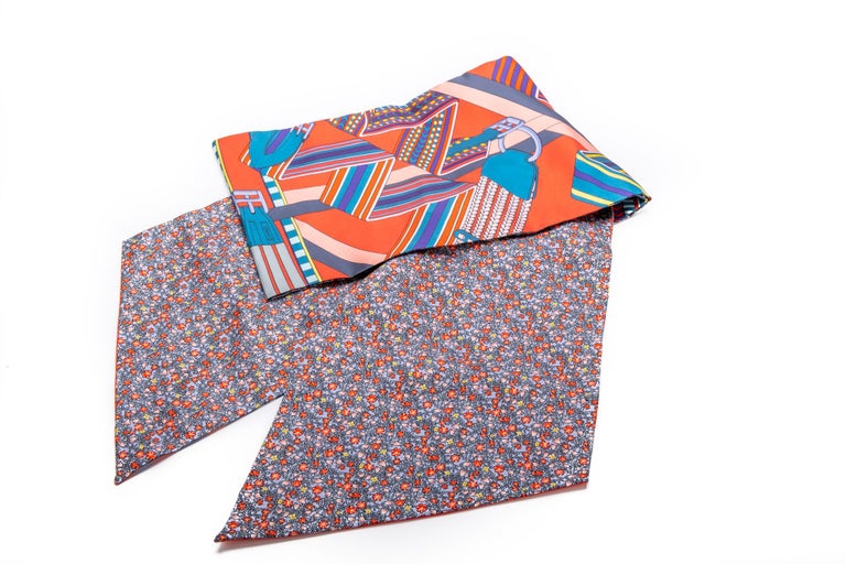 Hermès double-sided geometric and flowers orange and blue maxi twilly. 100% silk. Brand new with box and ribbon.
