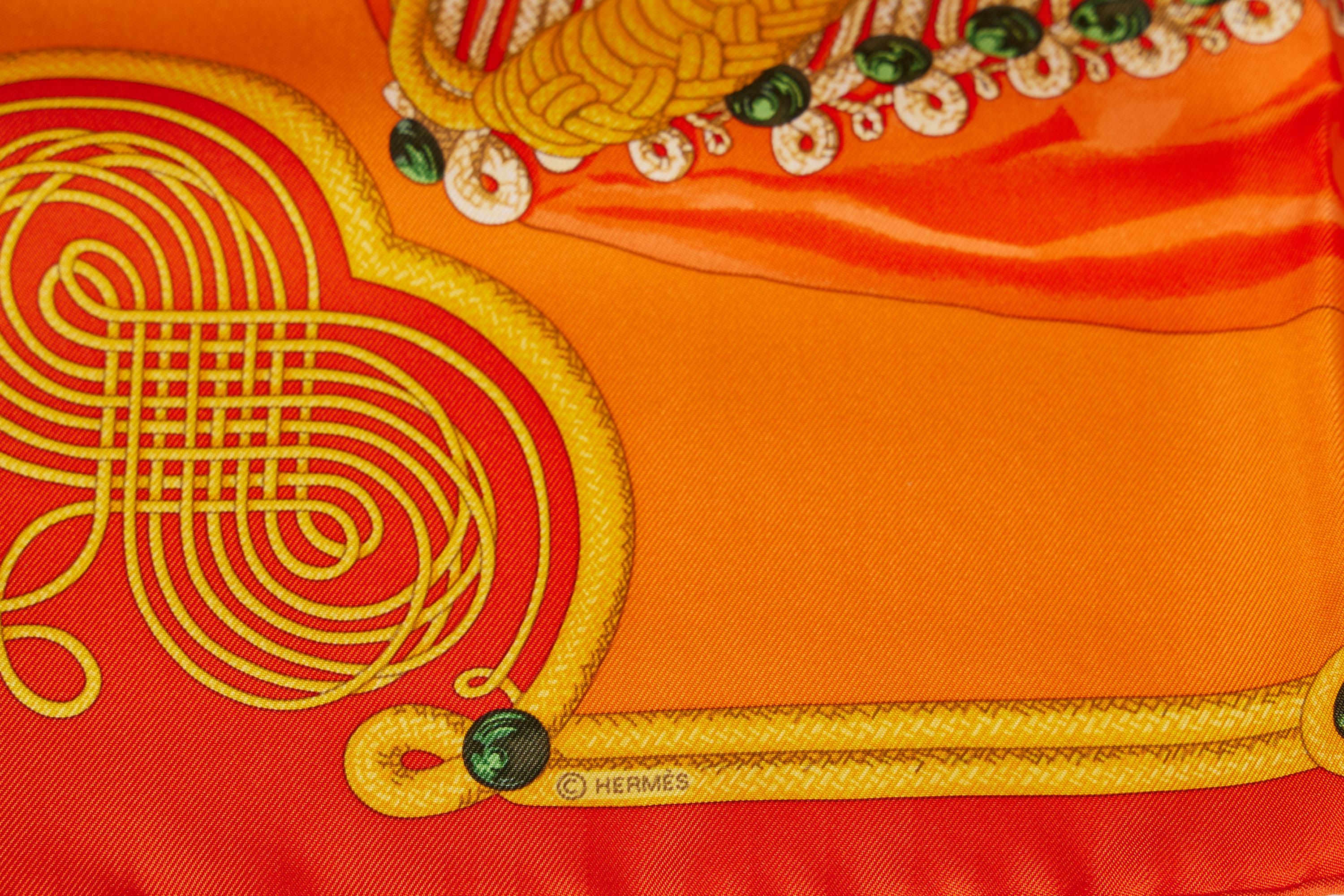 This beautiful Hermès silk twill scarf belong to the Brandenbourgs edition. One of the most sought after ones. It comes in bright orange and the details are beautifully seen on this handcrafted piece of art. The scarf comes with a original Hermès