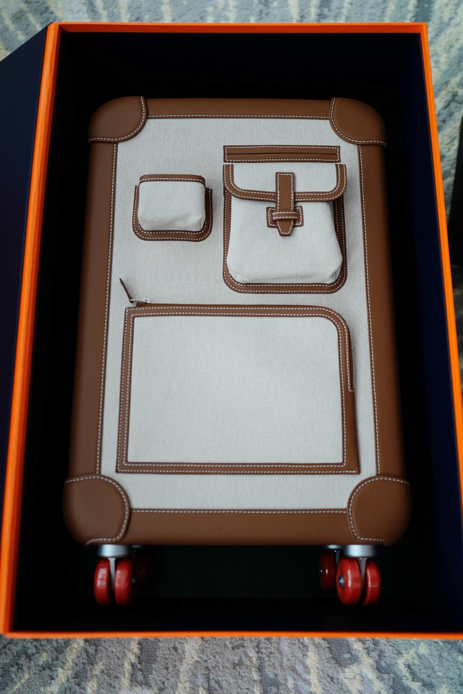 The Hermès Valise R.M.S Cargo Carry-On Suitcase in Beige and Fauve is a sophisticated travel essential that blends luxury with practicality. Crafted from durable beige canvas and accented with smooth Fauve leather trim, this piece showcases Hermès’