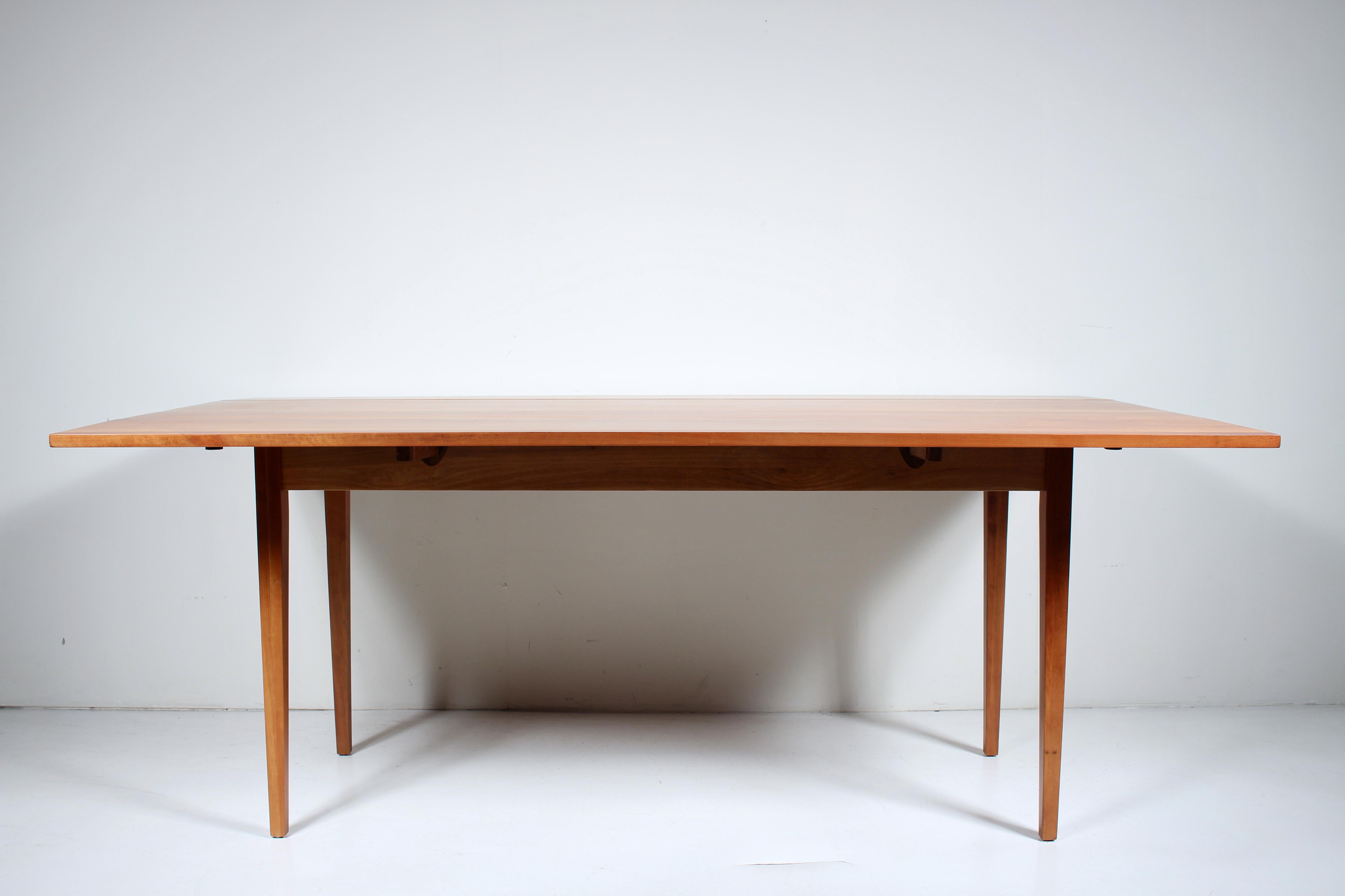 Table de salle à manger à abattant en cerisier de l'école de New Hope, circa 1960. Cette table est composée de panneaux en cerisier massif fabriqués en studio, de feuilles articulées, de 2 supports de tringles carrées extractibles par côté et de