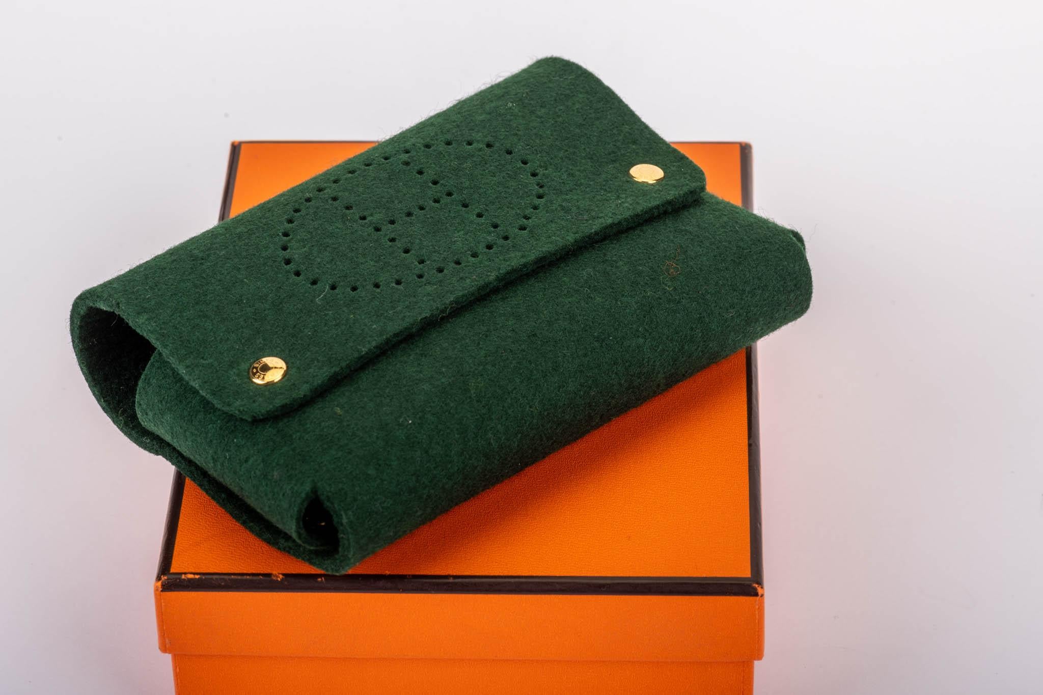 Hermès multifunctional felt pouch, with H perforated logo on front. Comes with original box.
