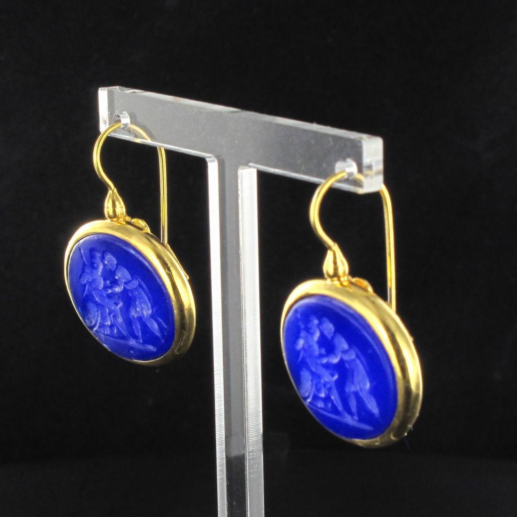 For pierced ears.
Pair of earrings in silver and yellow gold.
Lever- back shape, they are set with a blue cameo on glass paste representing a battle scene between 2 men. The hanging system is a swan neck with safety hook.
Length: 3.7 cm, width: 2.5