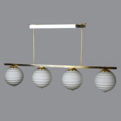New Italian Fixture with Four Pale Taupe Globes on Horizontal Brass Bar