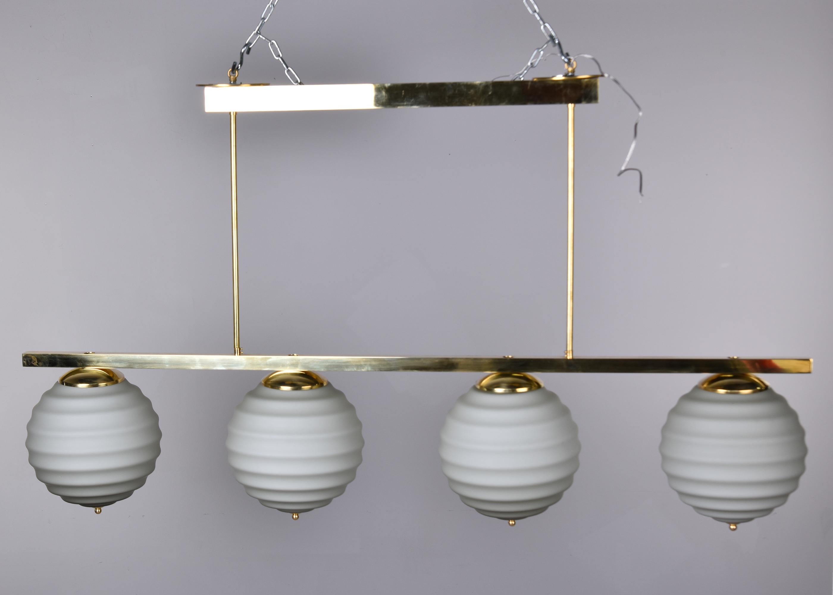 Contemporary New Italian Fixture with Four Pale Taupe Globes on Horizontal Brass Bar For Sale