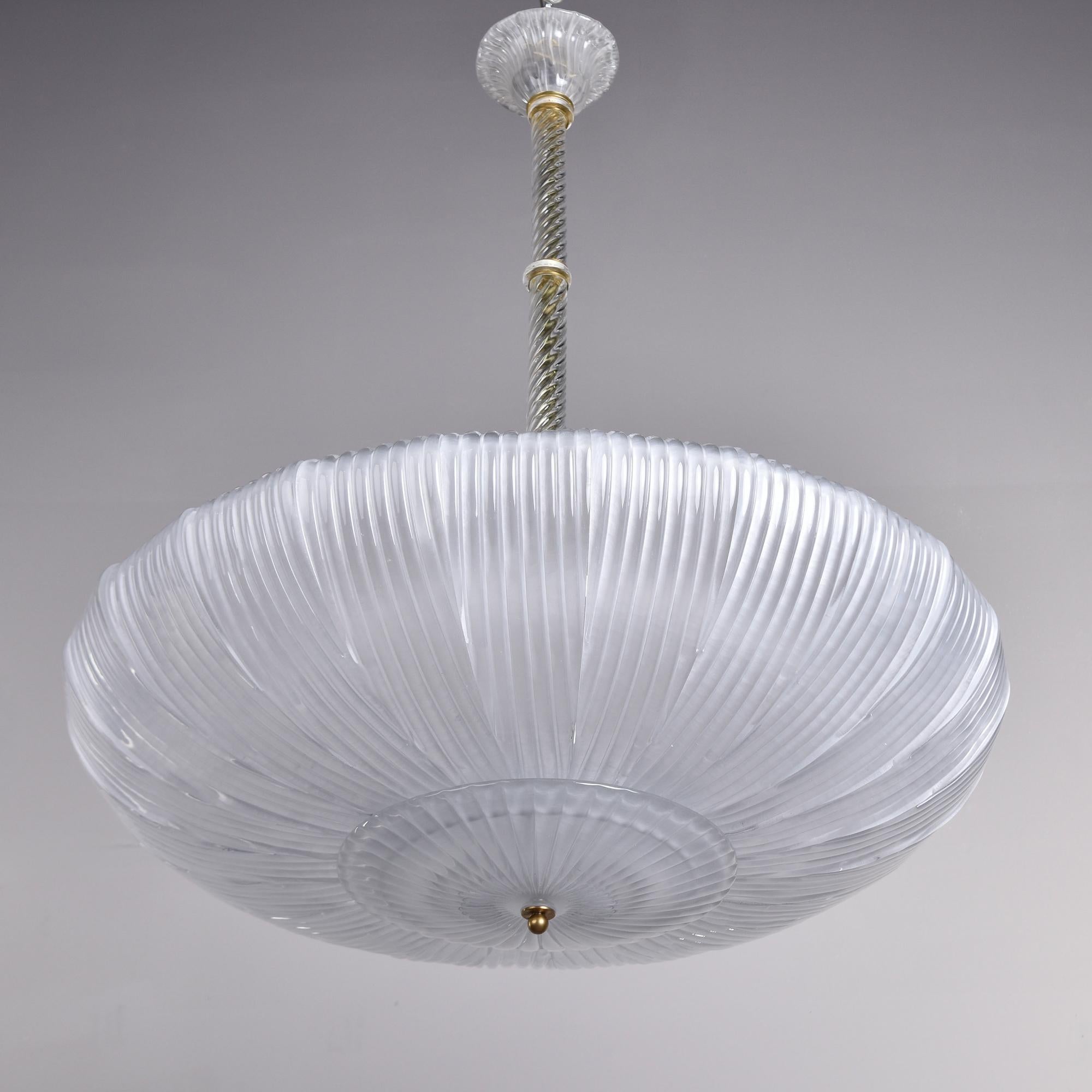 Made in Italy, this new pendant fixture is shaped like an upside down umbrella. The 36” diameter shade is made of several curved Murano glass petals suspended from a metal frame. This fixture has 6 regular sized sockets and a clear glass center