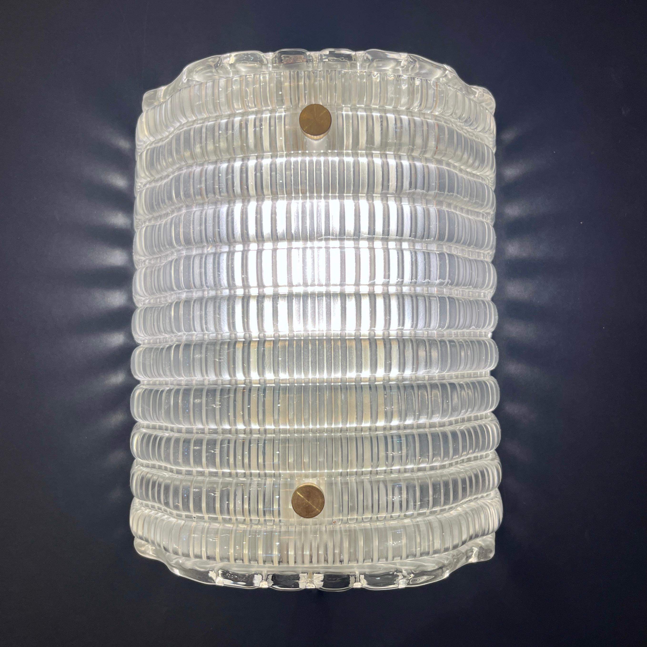 Stunning Italian pair of contemporary Italian modern sconces, inspired by the iconic designs of Gio Ponti. Entirely hand-crafted from luxurious reeded Murano crystal glass with a decorative pattern of semicylindrical adjacent moldings, these