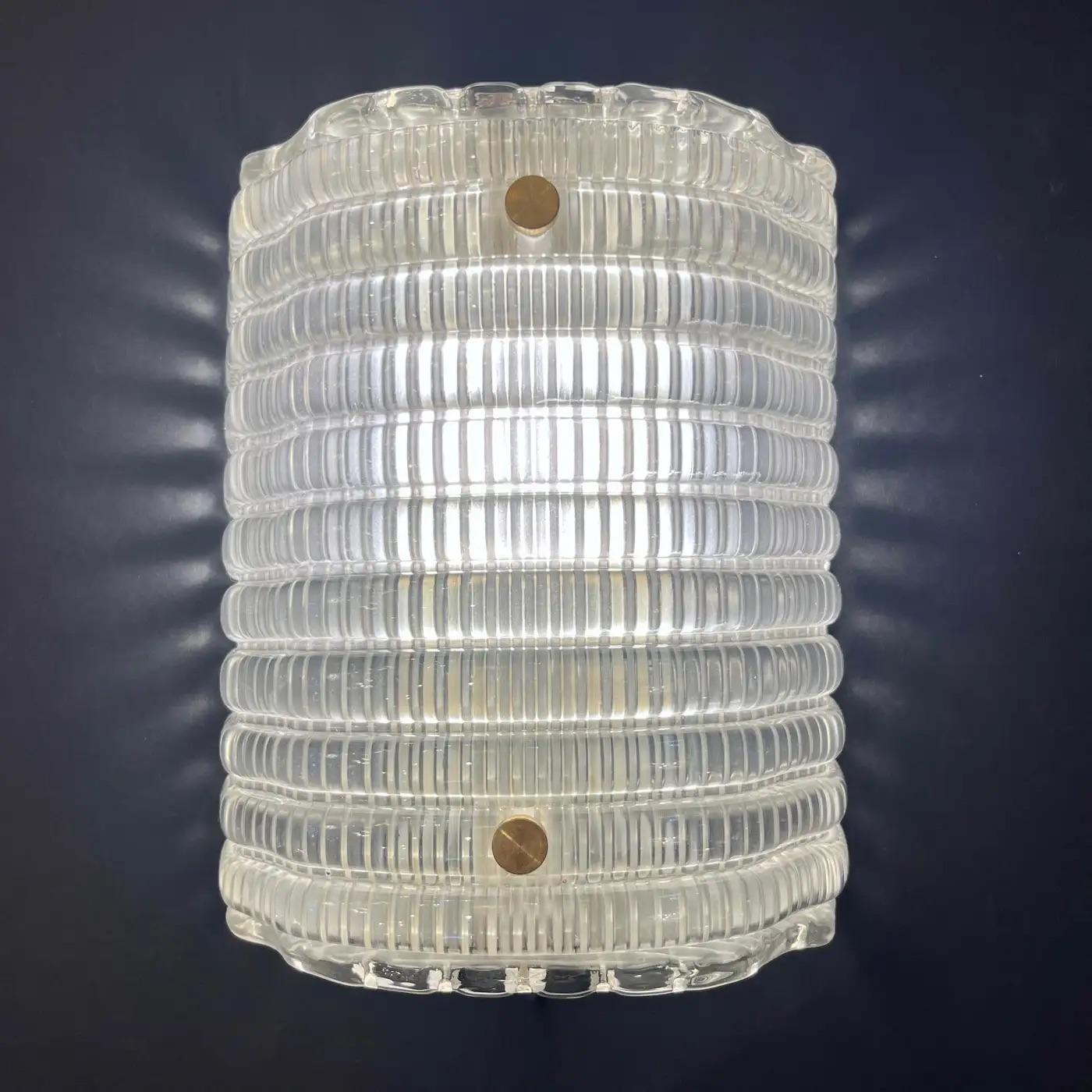 Stunning Italian pair of contemporary Italian modern sconces, inspired by the iconic designs of Gio Ponti. Entirely hand-crafted from luxurious reeded Murano crystal glass with a decorative pattern of semicylindrical adjacent moldings, these