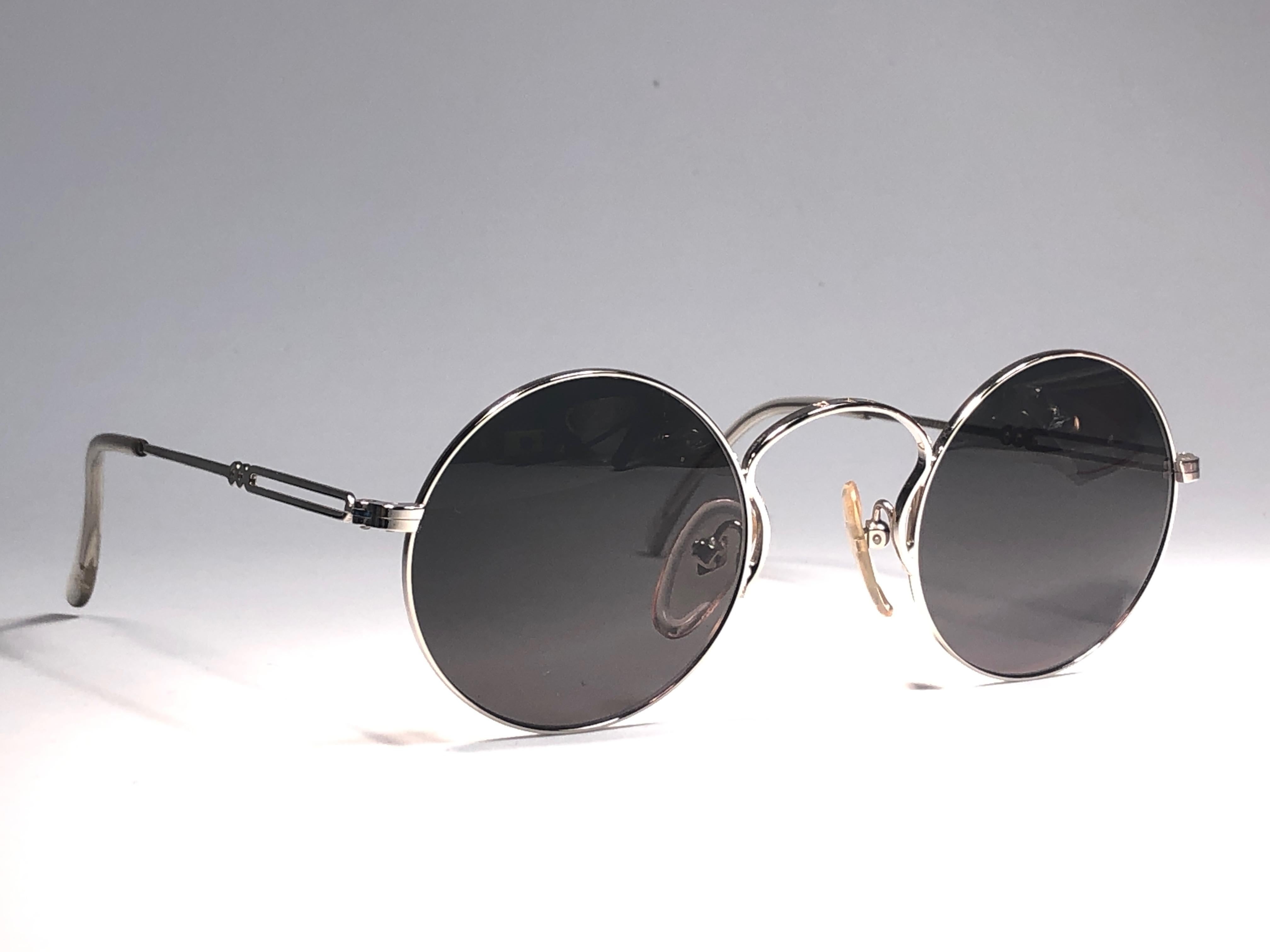 New Jean Paul Gaultier Small silver frame. 
Spotless grey lenses that complete a ready to wear JPG look.

Amazing design with strong yet intricate details.
Design and produced in the 1990's.
New, never worn or displayed.
This item may show minor