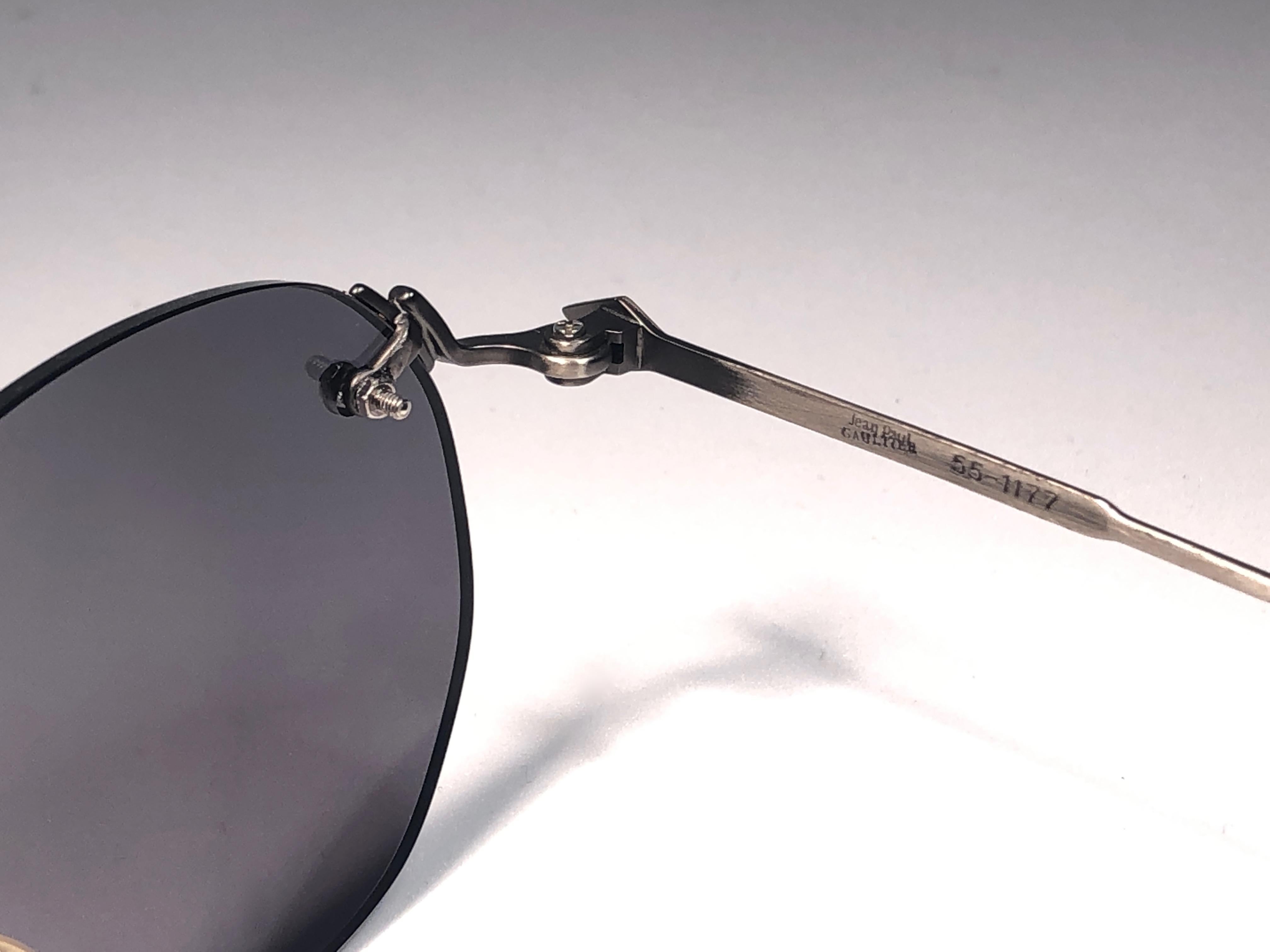 New Jean Paul Gaultier medium gunmetal rimless frame. 
Spotless smoke grey lenses that complete a ready to wear JPG look.

Amazing design with strong yet intricate details.
Design and produced in the 1990's.
New, never worn or displayed.
This item