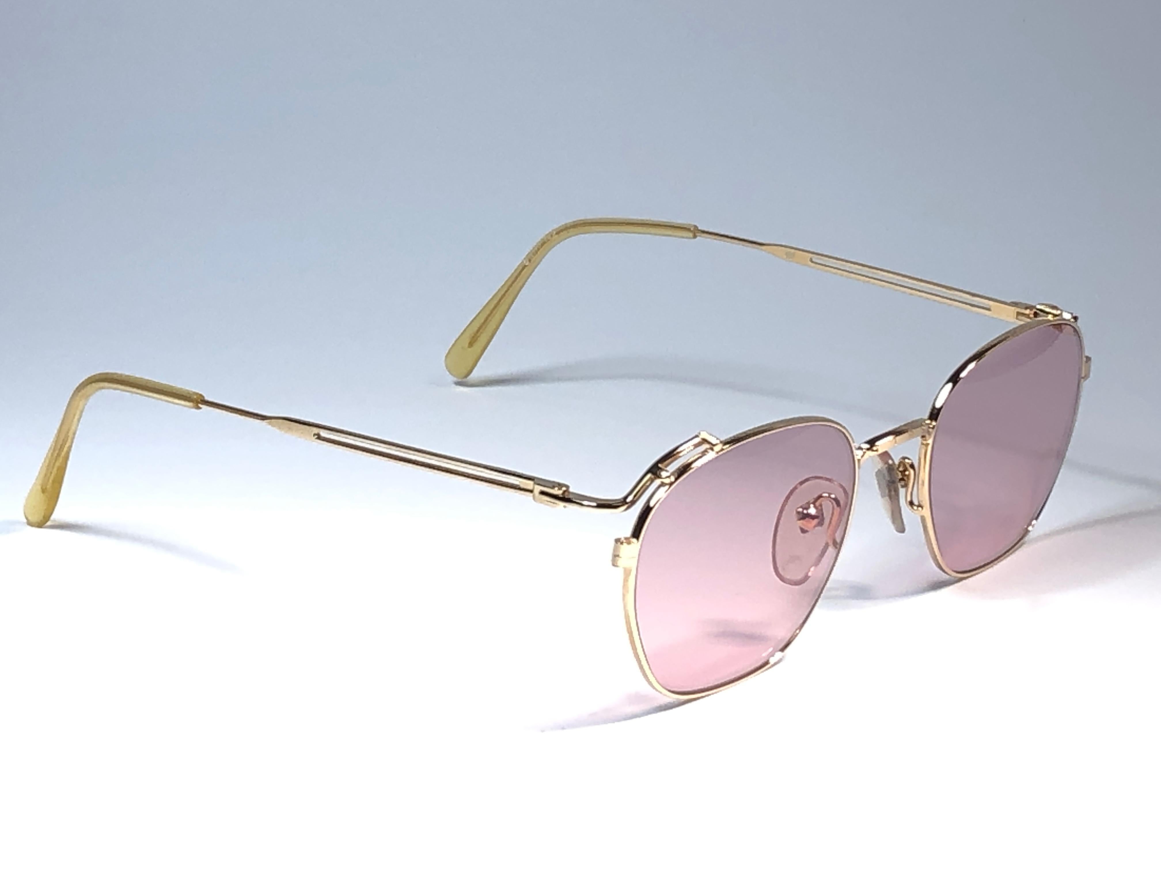 New Jean Paul Gaultier small oval gold frame. 
Spotless light mauve lenses that complete a ready to wear JPG look.

Amazing design with strong yet intricate details.
Design and produced in the 1990's.
New, never worn or displayed.
A true fashion