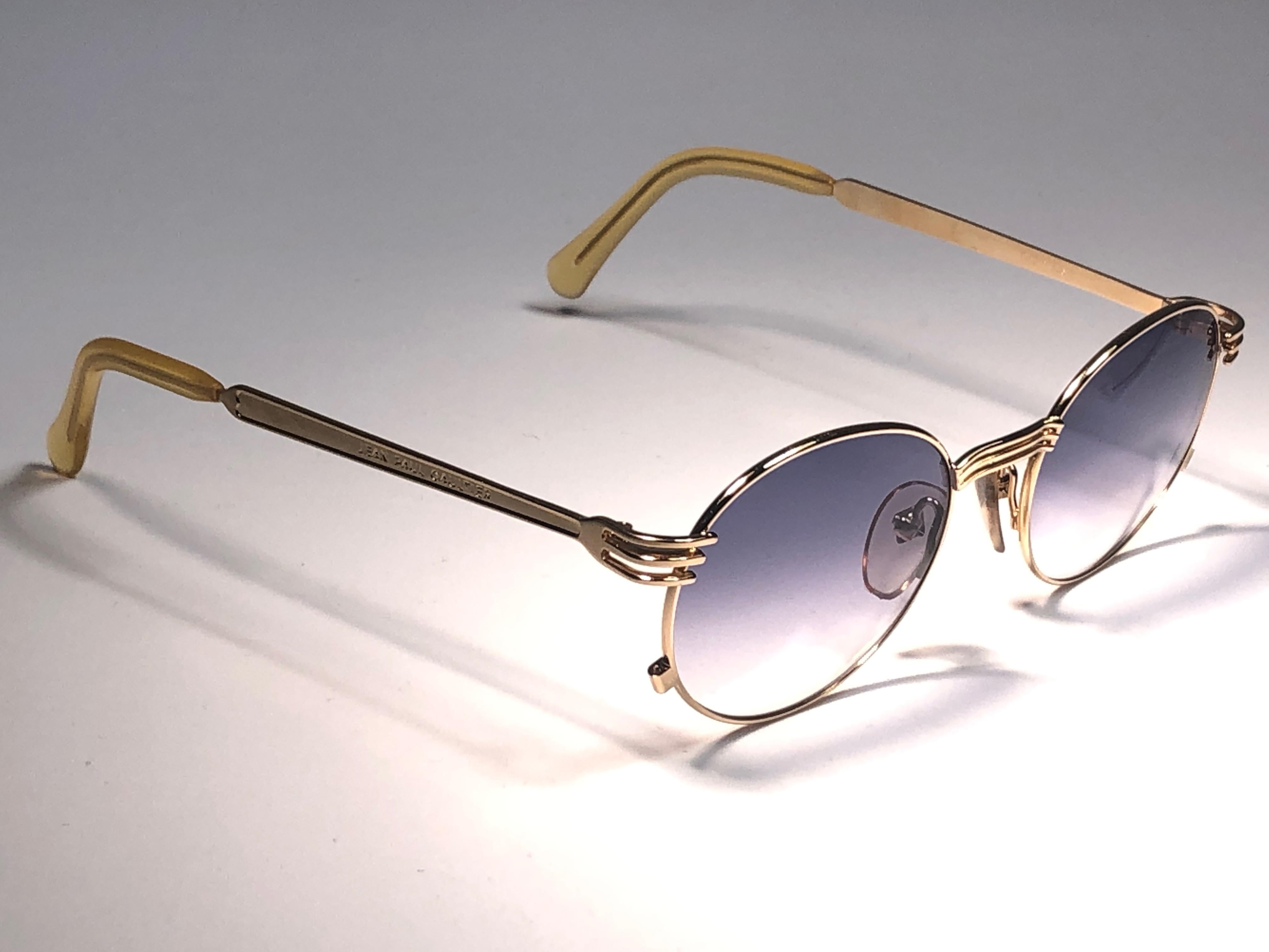 New Jean Paul Gaultier medium gold fork details frame. 
Spotless light blue lenses that complete a ready to wear JPG look.

Amazing design with strong yet intricate details.
Design and produced in the 1990's.
New, never worn or displayed.
This item