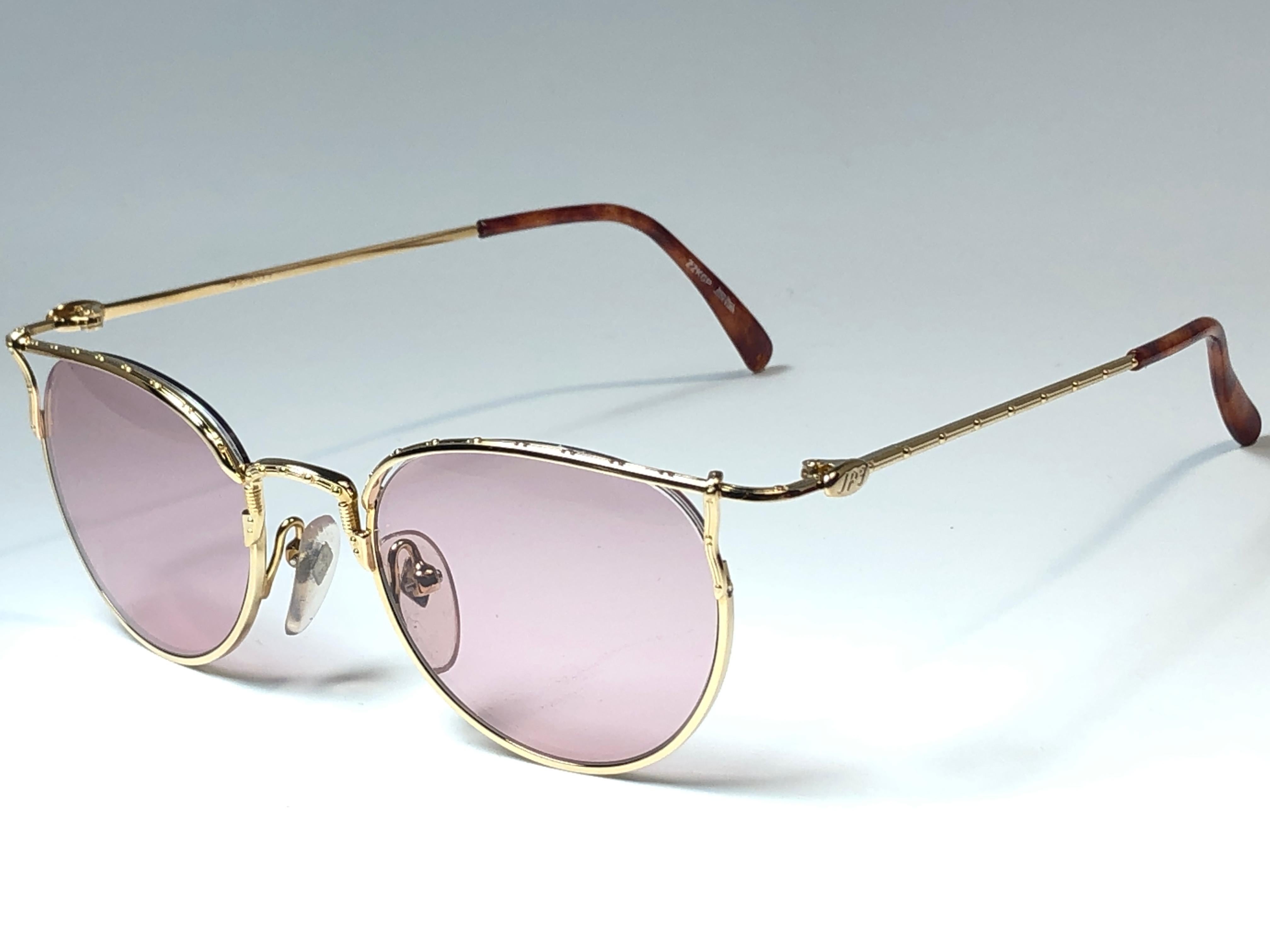 New Jean Paul Gaultier small oval 22K gold plated frame. 
Spotless light mauve lenses that complete a ready to wear JPG look.

Amazing design with strong yet intricate details.
Design and produced in the 1990's.
New, never worn or displayed.
A true