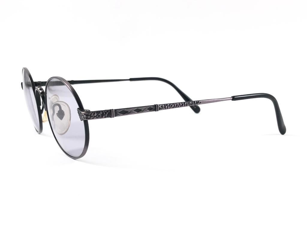 New Jean Paul Gaultier medium black & copper frame. 
Light grey lenses that complete a ready to wear JPG look.

Amazing design with strong yet intricate details.
Design and produced in the 1990's.
New, never worn or displayed.
This item may show