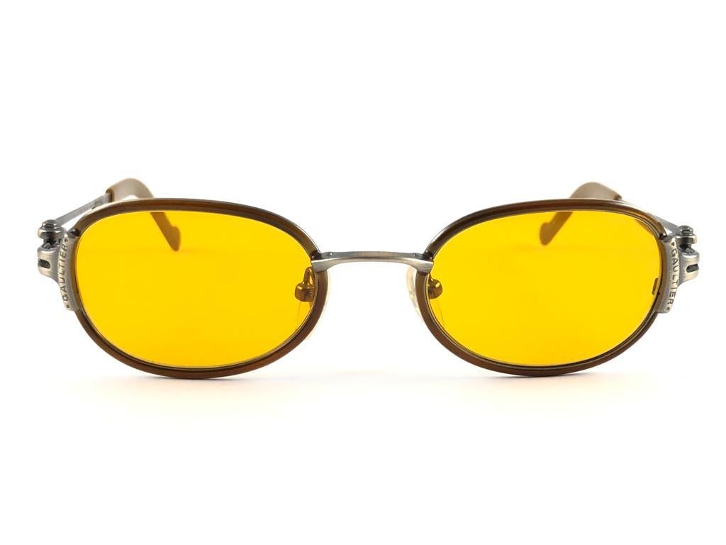 New Jean Paul Gaultier medium copper frame. 
Amber yellow lenses that complete a ready to wear JPG look.

Amazing design with strong yet intricate details.
Design and produced in the 1990's.
New, never worn or displayed.
This item may show minor