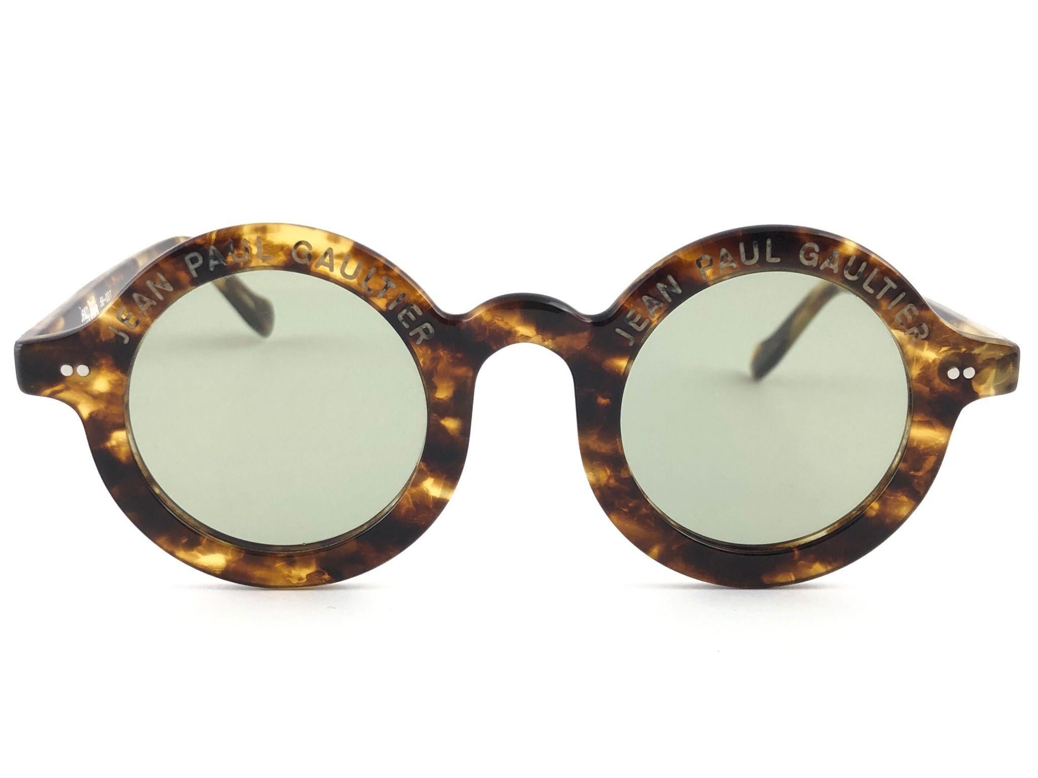 
New Jean Paul Gaultier 56 0071 Iconic round tortoise frame. 
Flat grey lenses that complete a ready to wear JPG look.
Amazing quality and design. A piece of sunglasses history.
This pair has minor sign of wear due to nearly 30 years of storage.