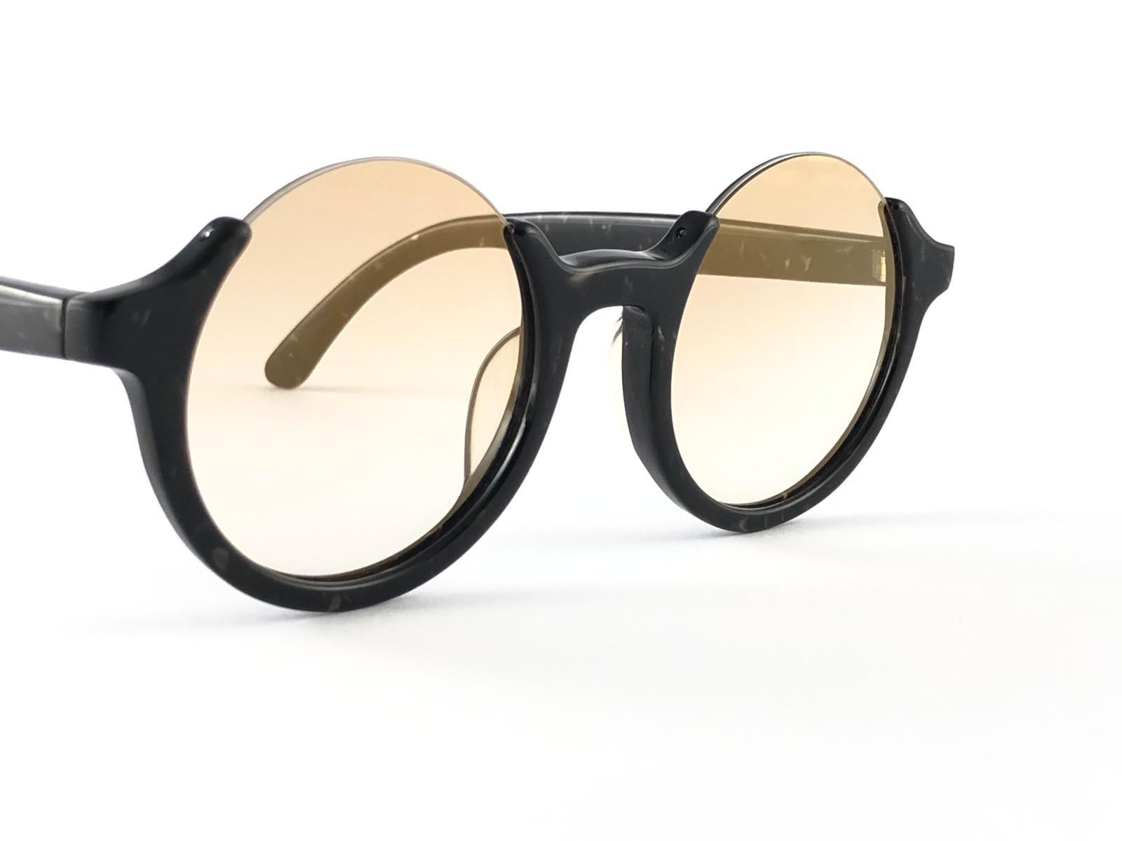 
New Jean Paul Gaultier 56 7061 round black marbled frame. 
Flat lenses that complete a ready to wear JPG look.
Amazing quality and design. A piece of sunglasses history.
This pair has minor sign of wear due to nearly 30 years of storage. 
Design
