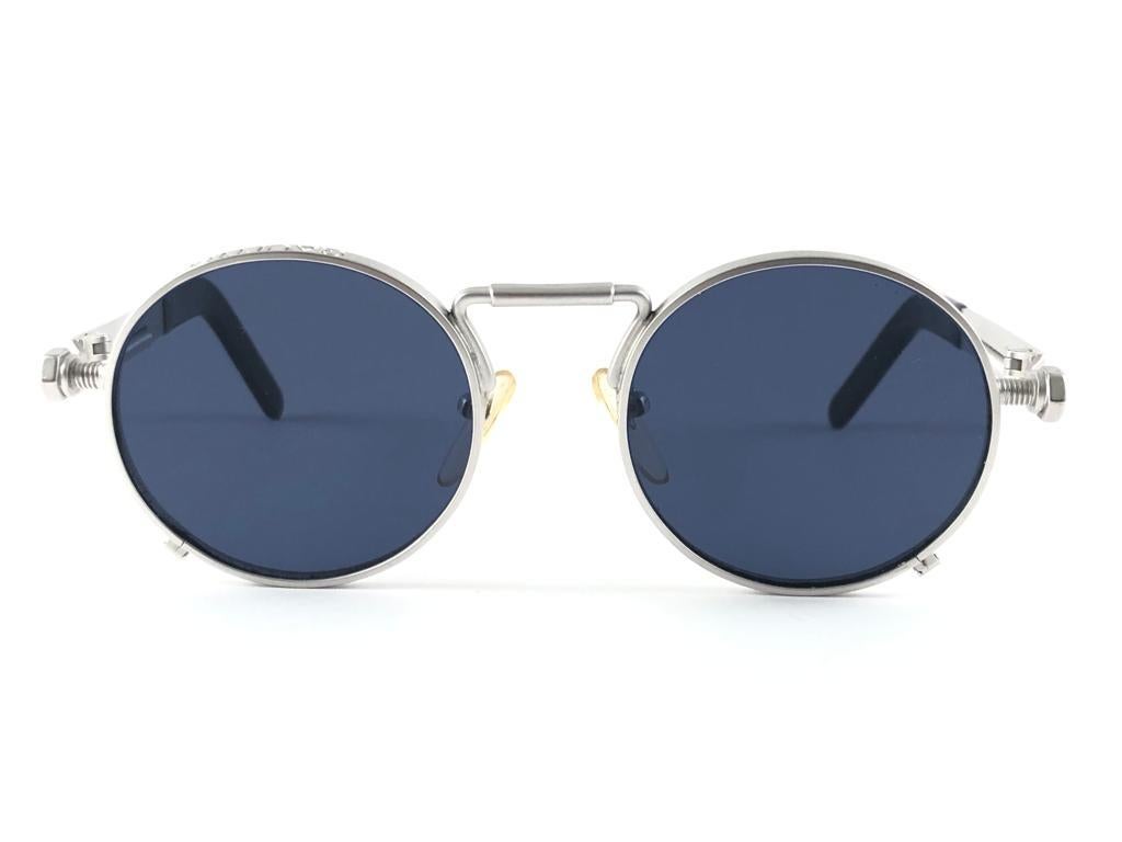 
New Jean Paul Gaultier 56 8171 round gunmetal silver matte frame. 
Flat smoke grey lenses that complete a ready to wear JPG look.

Amazing design with strong yet intricate details.
Design and produced in the 1900's.
New, never worn or displayed.
