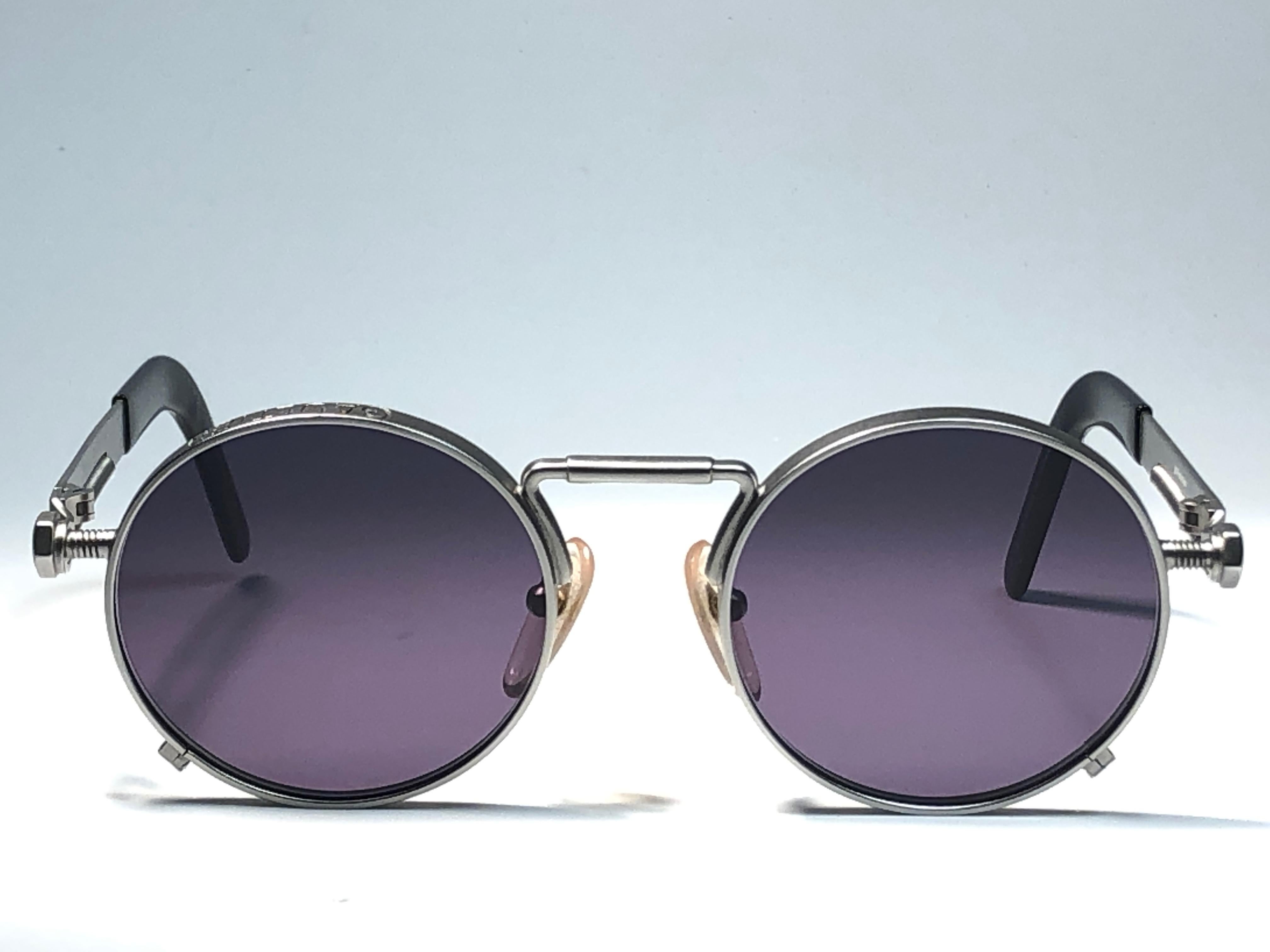 
New Jean Paul Gaultier 56 8171 round gunmetal silver matte frame. 
Flat smoke grey lenses that complete a ready to wear JPG look.

Amazing design with strong yet intricate details.
Design and produced in the 1900's.
New, never worn or displayed.