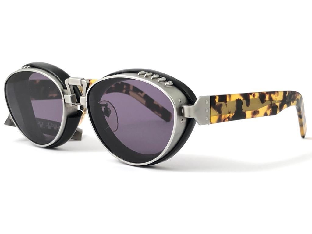 
Collectors Item!!

iconic Jean Paul Gaultier 56 8207 robust tortoise with silver matte frame with rubber inserts frame. 

Dark grey flat lenses that complete a ready to wear jpg look.
The very same model worn by Yusaku Matsuda in 1989 Ridley