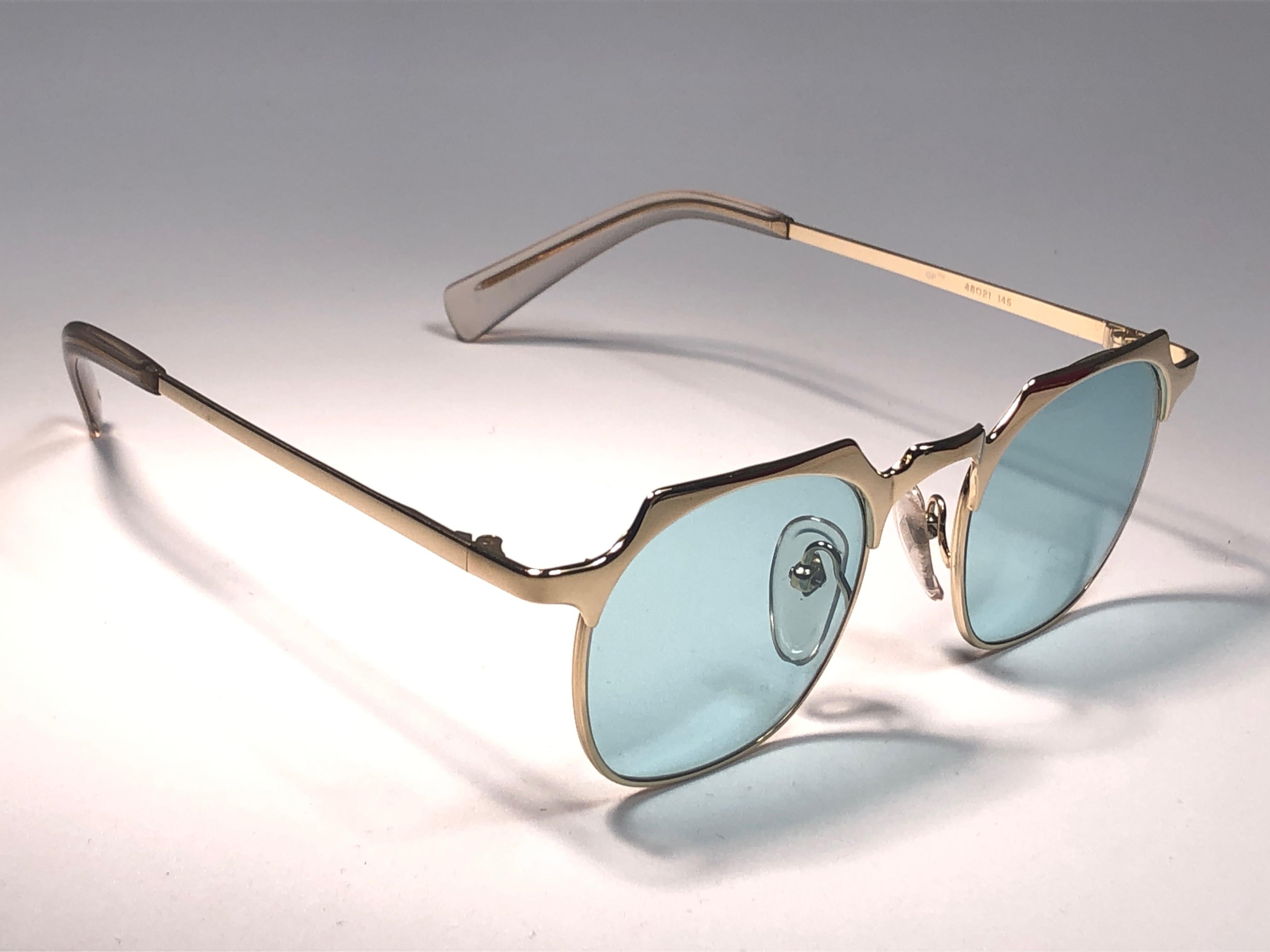 New Jean Paul Gaultier medium gold frame. 
Spotless light blue lenses that complete a ready to wear JPG look.

Amazing design with strong yet intricate details.
Design and produced in the 1990's.
New, never worn or displayed.
This item may show
