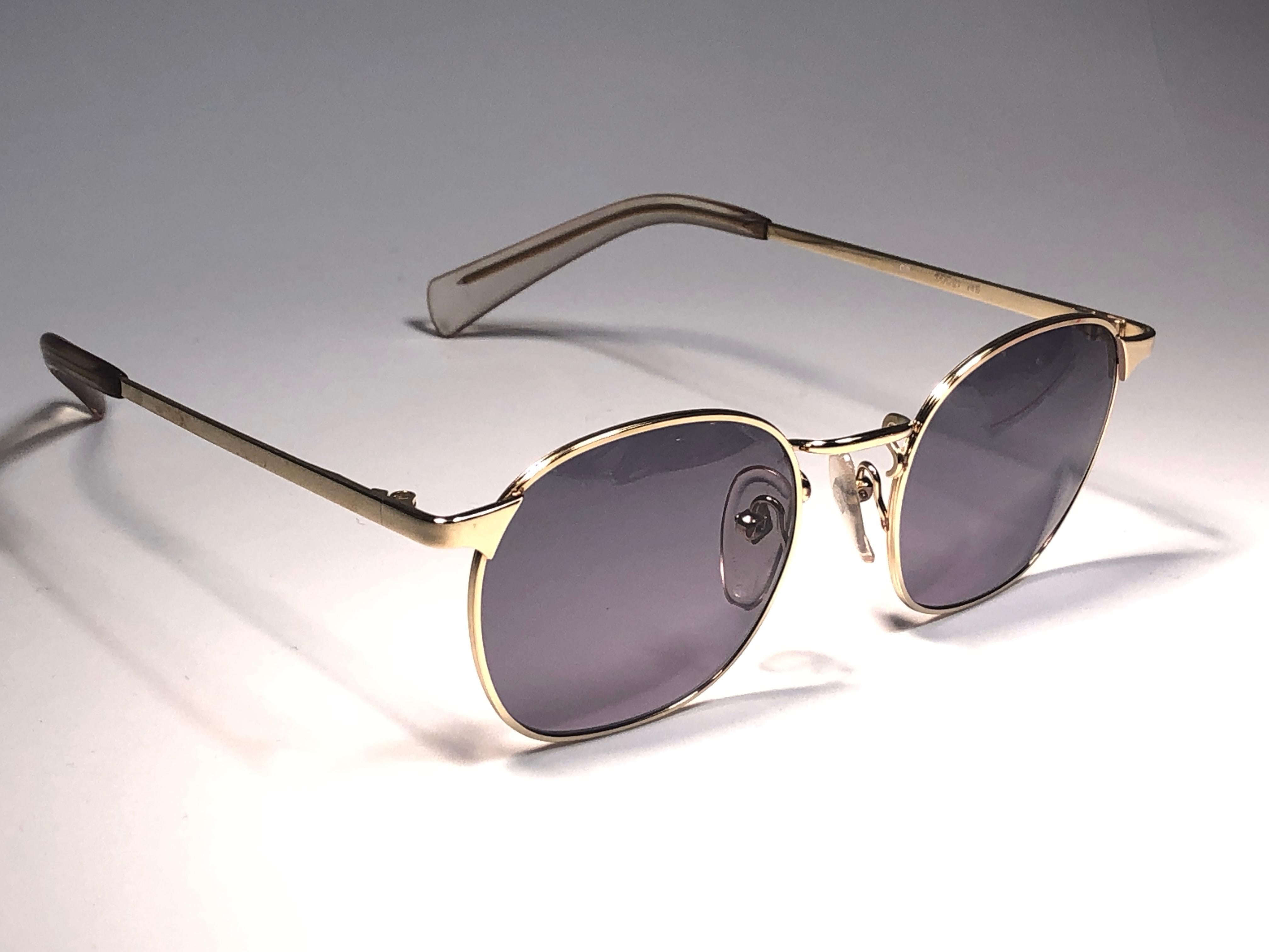 New Jean Paul Gaultier medium gold frame. 
Spotless grey lenses that complete a ready to wear JPG look.

Amazing design with strong yet intricate details.
Design and produced in the 1990's.
New, never worn or displayed.
This item may show minor sign