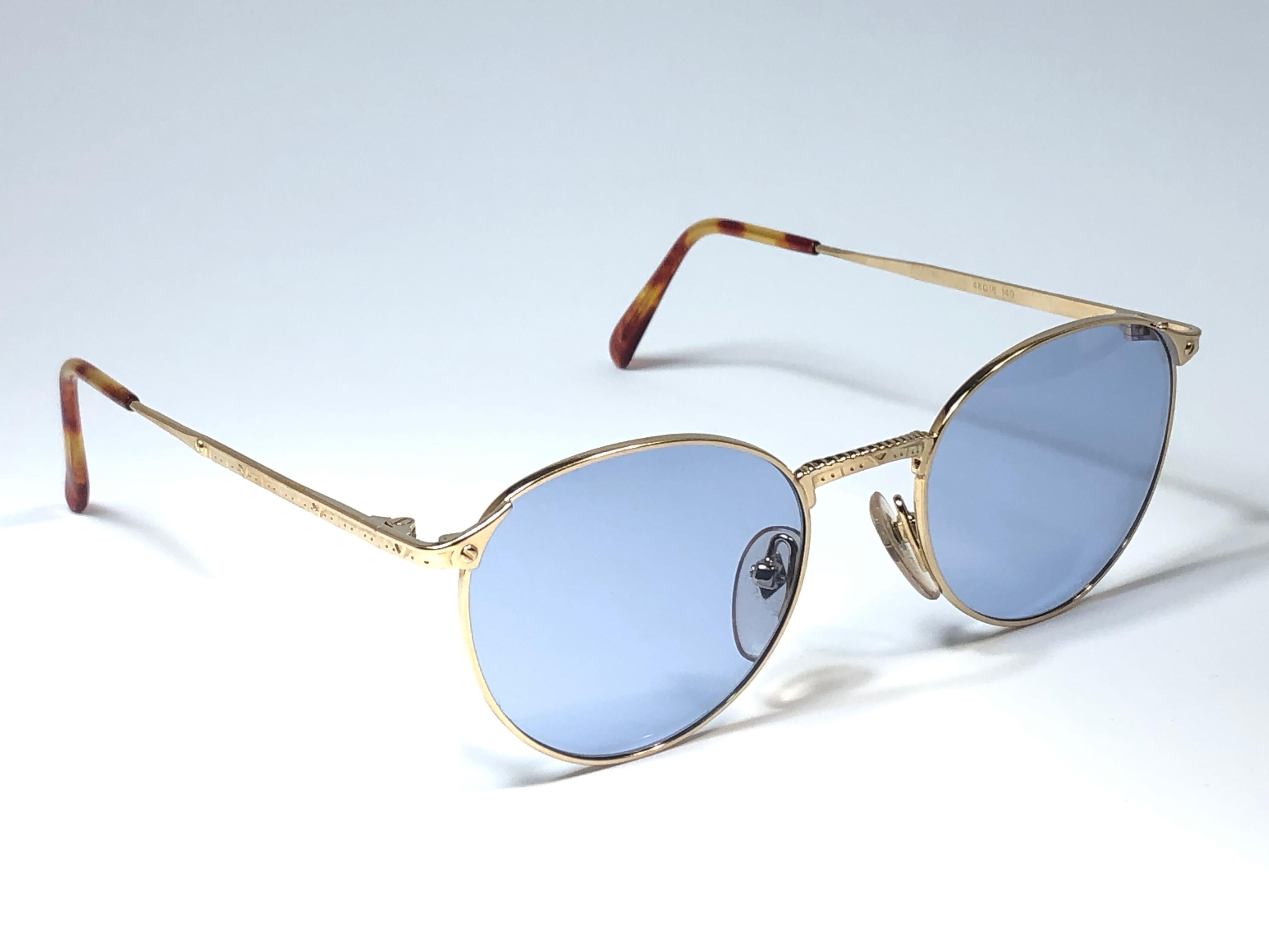 New Jean Paul Gaultier small oval gold frame. 
Spotless light blue lenses that complete a ready to wear JPG look.

Amazing design with strong yet intricate details.
Design and produced in the 1990's.
New, never worn or displayed.
A true fashion