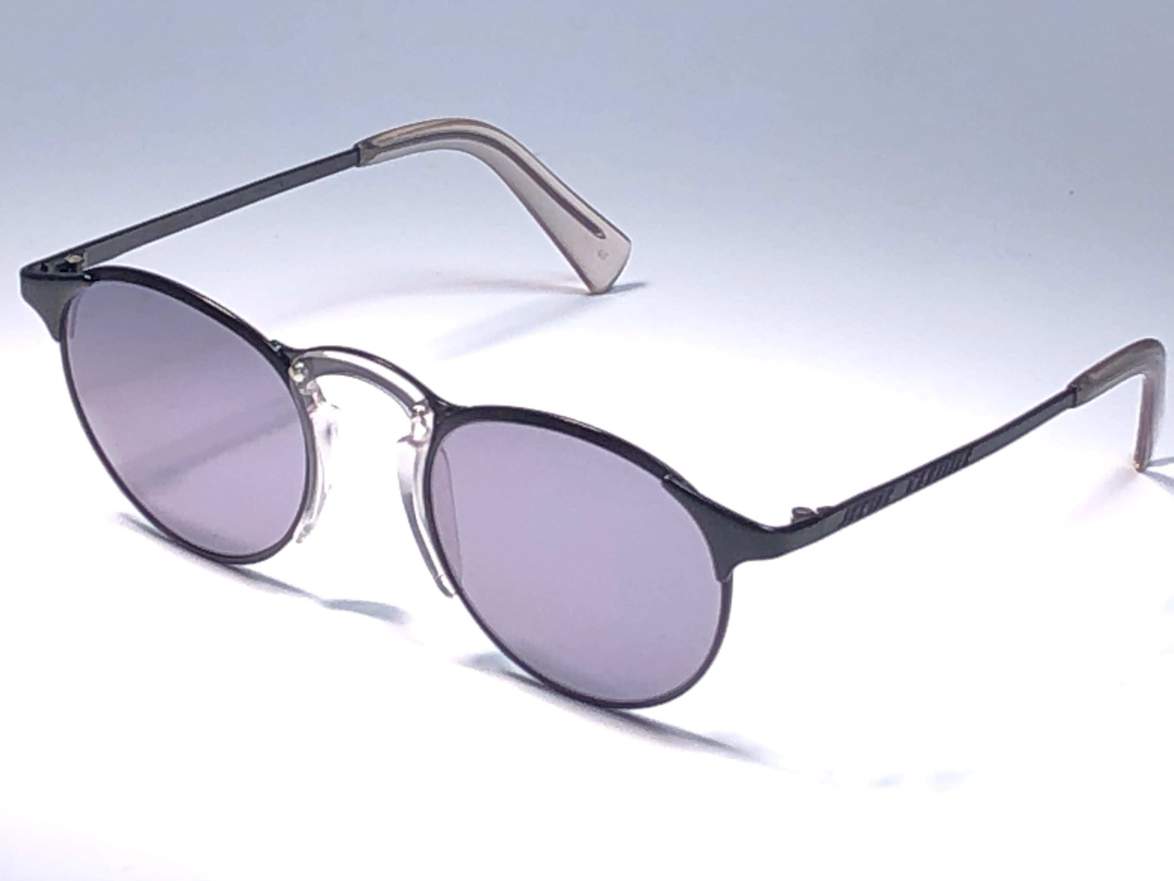 &New Jean Paul Gaultier Sonnenbrille mit schwarzem Rahmen.
Makellose, rauchgraue Gläser, die einen tragbaren JPG-Look vervollständigen.

Erstaunliches Design mit starken, aber raffinierten Details.
Design und Herstellung in den 1990er Jahren.
Neu,