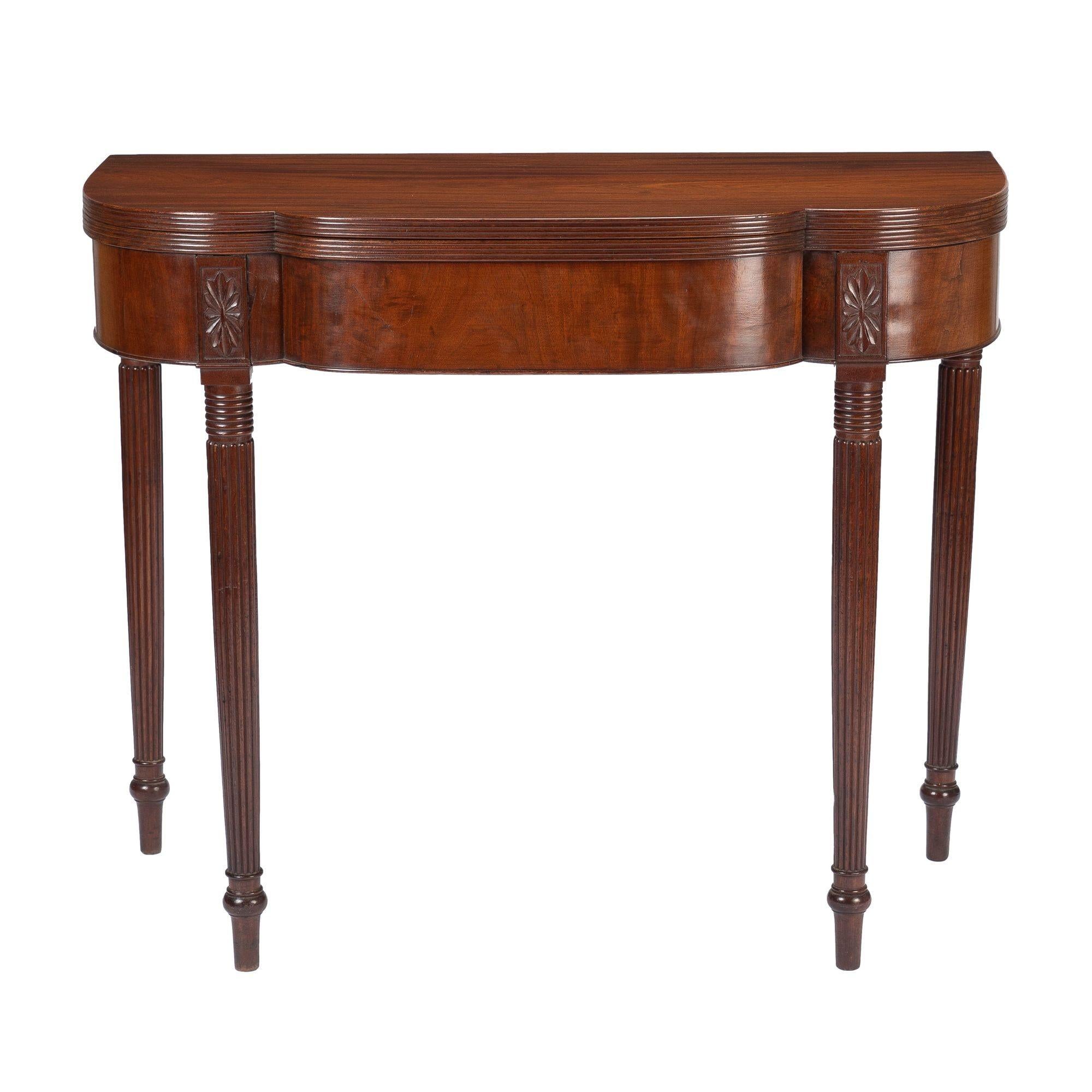 American Sheraton dimpled corner flip top game table with gated swing leg. The edges of the top are finely reeded and mounted to a conforming figured cherry veneered apron. The apron is punctuated by carved leg dies continuing into tapered, turned,