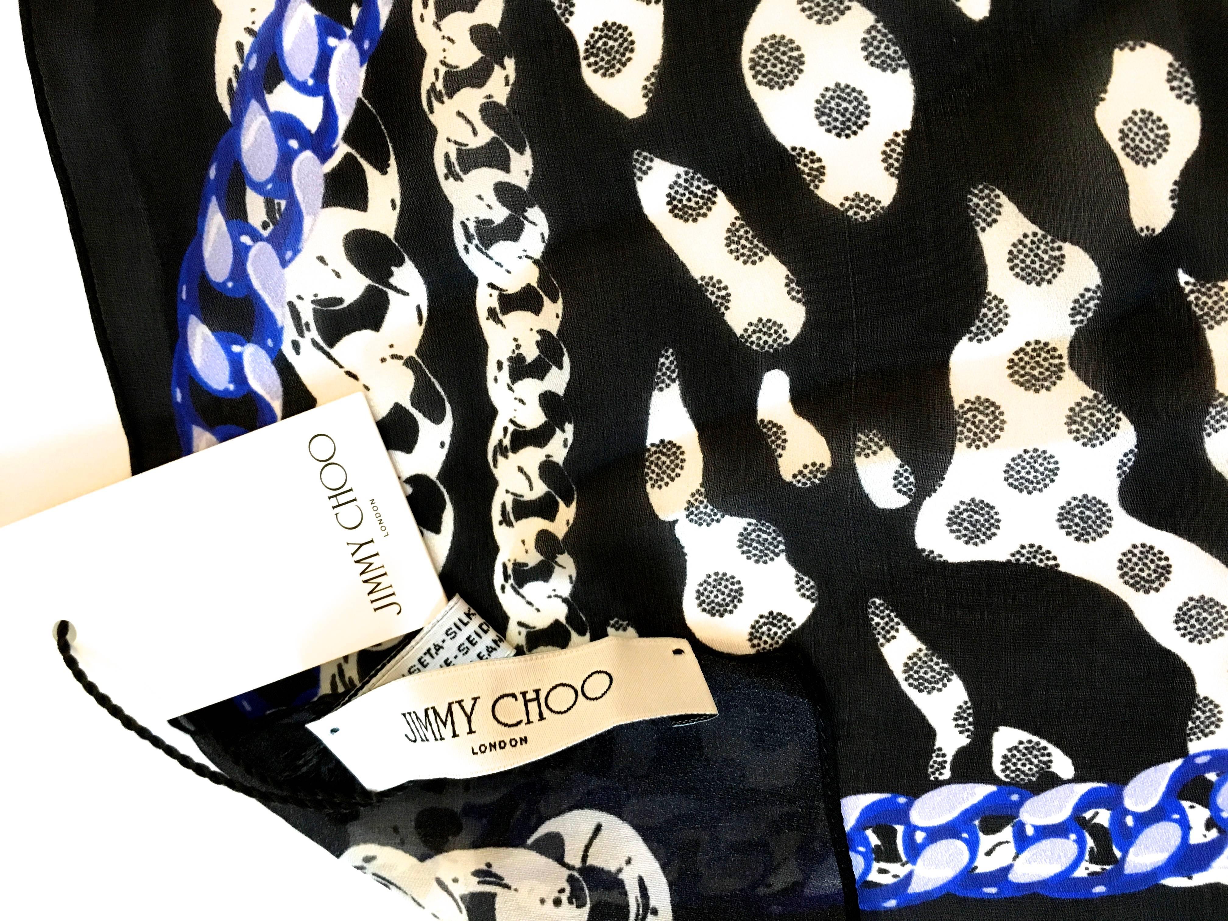 Presented here is an absolutely fabulous Jimmy Choo shawl with the tags on it. It is signed 'Jimmy Choo' on the bottom right. The shawl has a black background with a center free form design of white with various black non-representational images