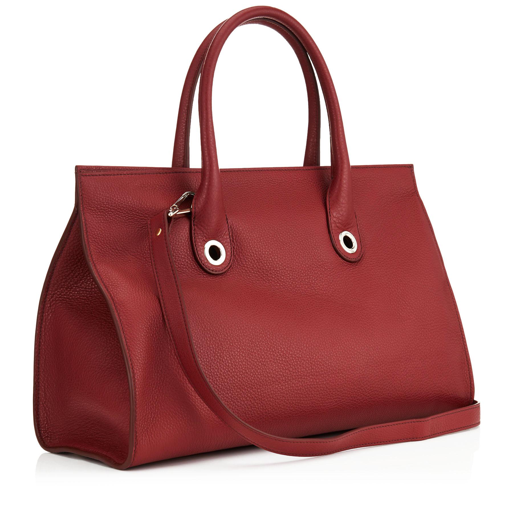 This popular Jimmy Choo Riley's Grainy Calf Leather Cross-body Bag in Red ( Wine ). The over sized tote bag is trimmed with gold-toned hardware. The opening features a flip-lock closure at front and 4 protective metal feet on bottom. The removable