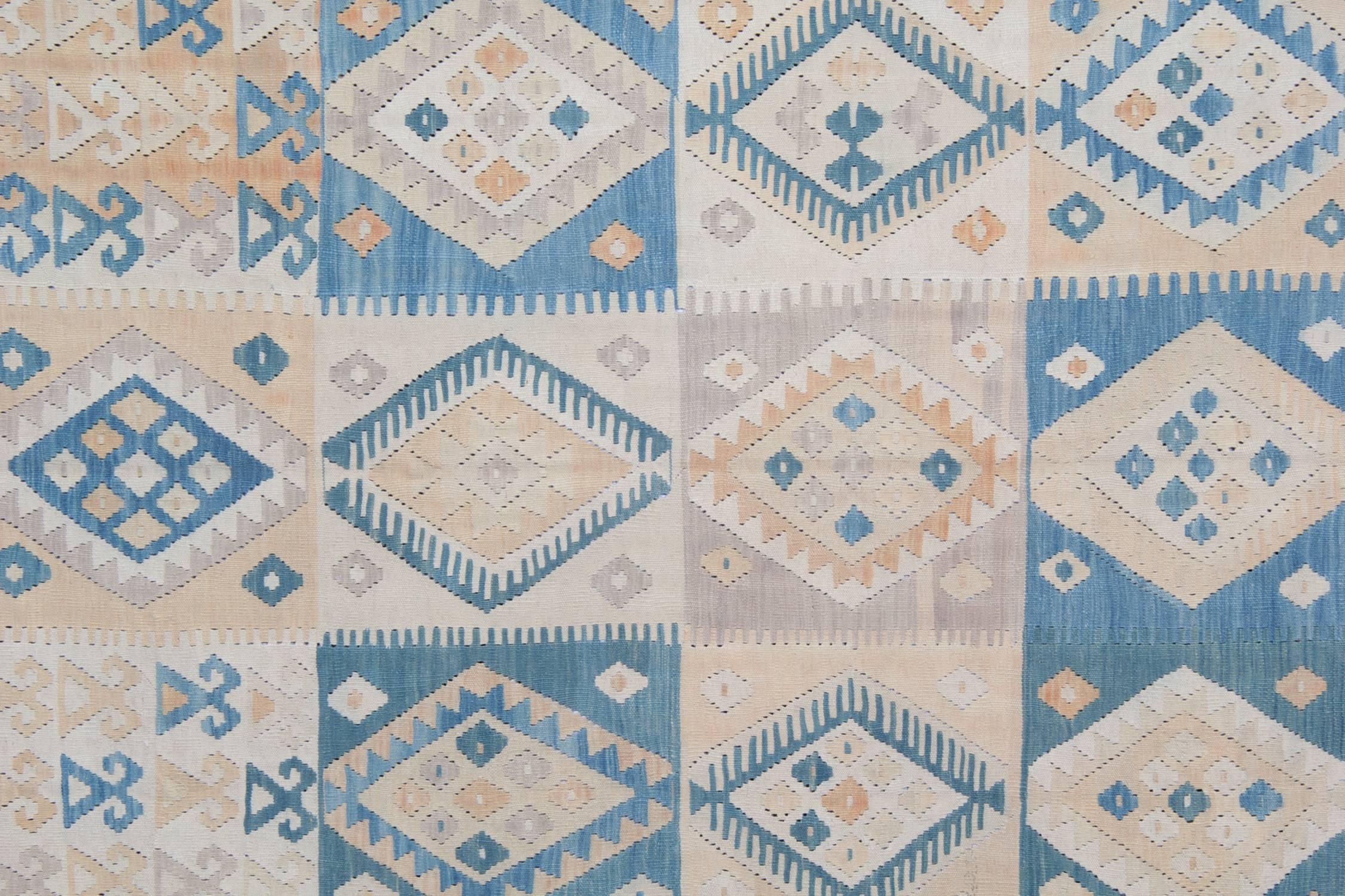 This blue rug is a flat-weave rug, which has been carefully handwoven with the highest quality wool and cotton in Afghanistan. The background of this woven rug is beige, which makes the small blue patterns all-over it stand out. The border of this