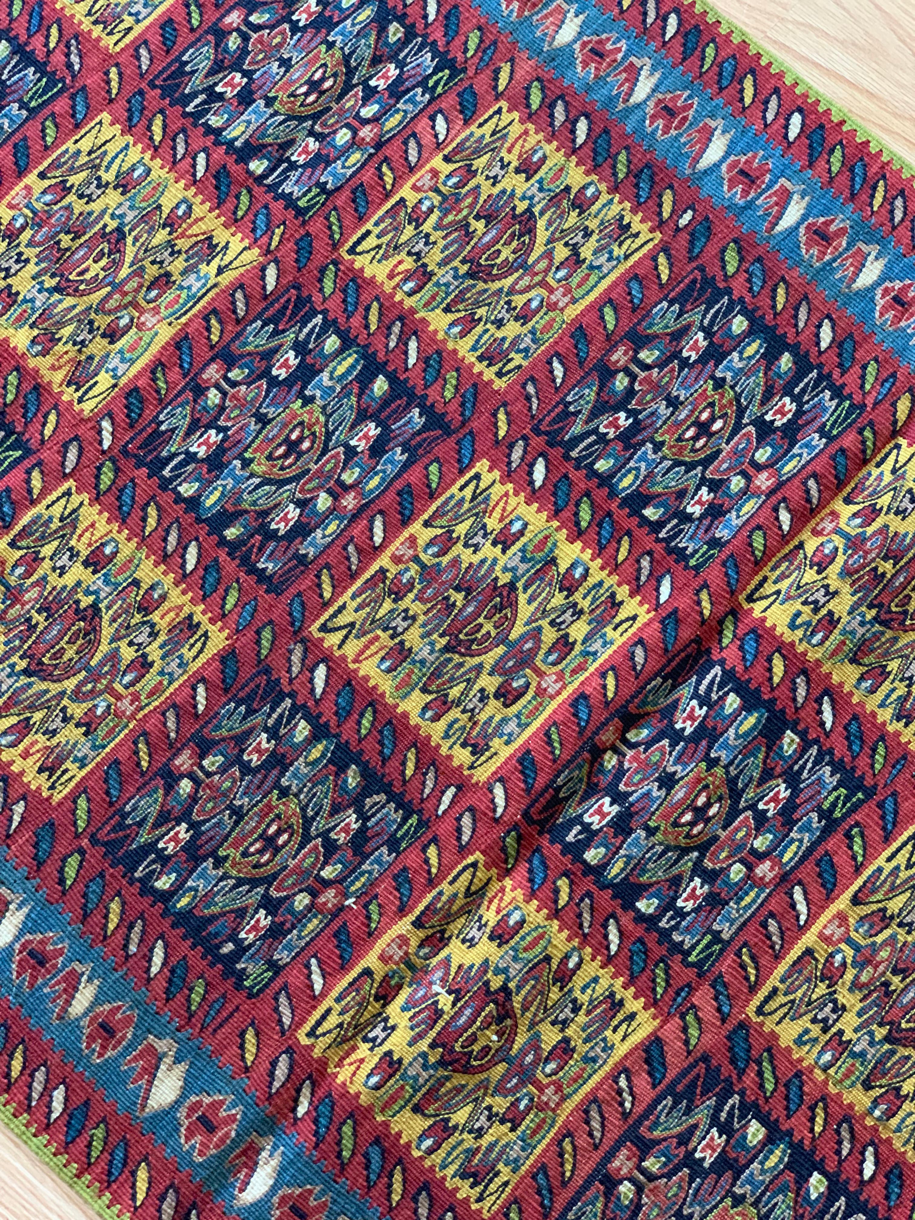 Ce magnifique tapis de couloir en pure laine est un kilim tissé à la main et à plat au début du 21e siècle, vers 2010. Elle n'a jamais été utilisée et est donc en excellent état. Le motif central a été tissé sur un fond rouge rouille et présente un