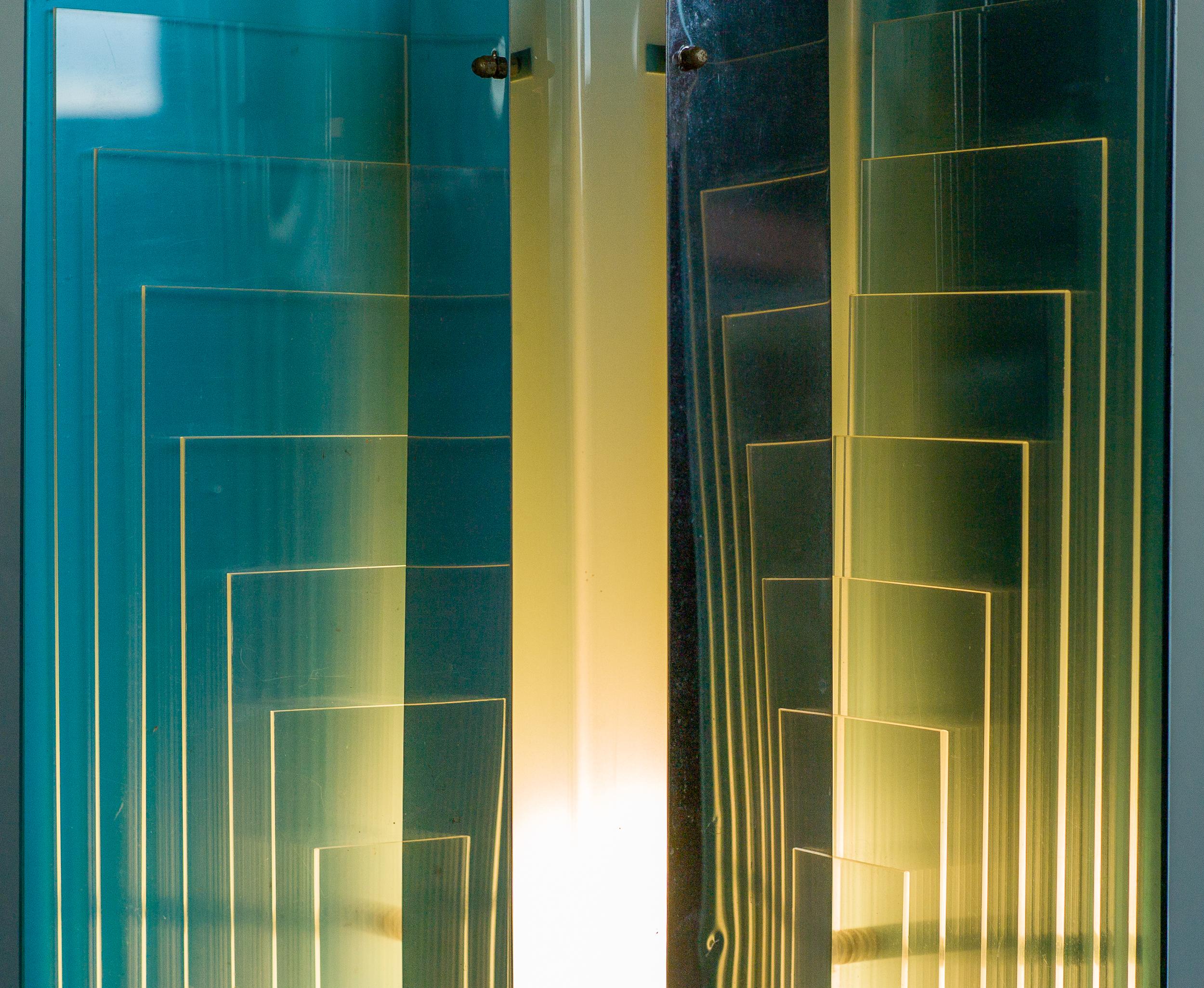 Large architectural table or floor lamp, attributed to New Lamp, manufactured in Italy in the 1970s.
The light of the three-light bulbs behind the opaline plexiglas centre column exits through the edges of the clear plexiglas sheets making the lamp