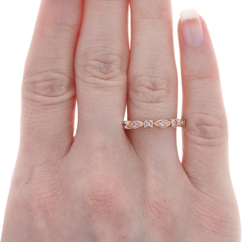 Treat yourself to something sweet with this beautiful NEW ring! Fashioned in glowing 14k rose gold, this band showcases a meaningful eternity design adorned with a glistening array of light pink sapphires.   

This ring is a size 7. Please contact