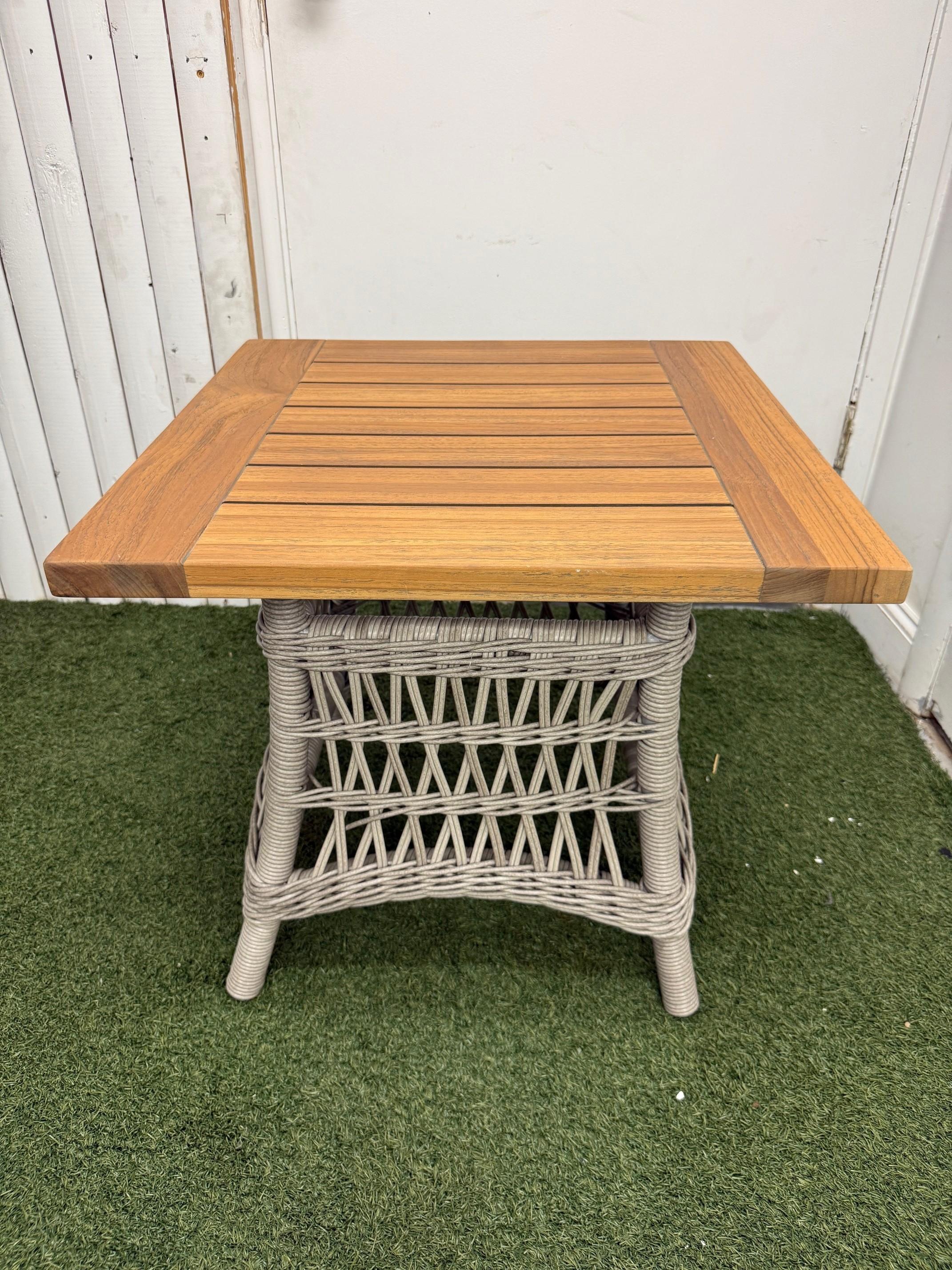 New Lloyds Flanders Mackinac woven vinyl end table with teak top. Idéal pour l'aménagement d'un salon extérieur ou d'une salle de séjour.
La base de la table présente un style de tissage ouvert avec des bordures de tissage rond plus serrées pour un