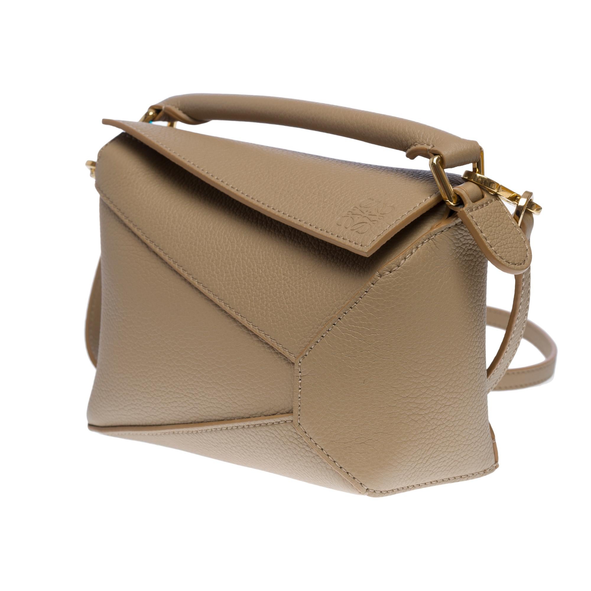 Very Chic Cuboid Loewe Puzzle Mini shoulder bag in grey calf leather designed by the artistic director of the brand Jonathan Anderson
Gold-tone metal hardware, simple gray leather handle, removable gray leather strap for hand or shoulder or