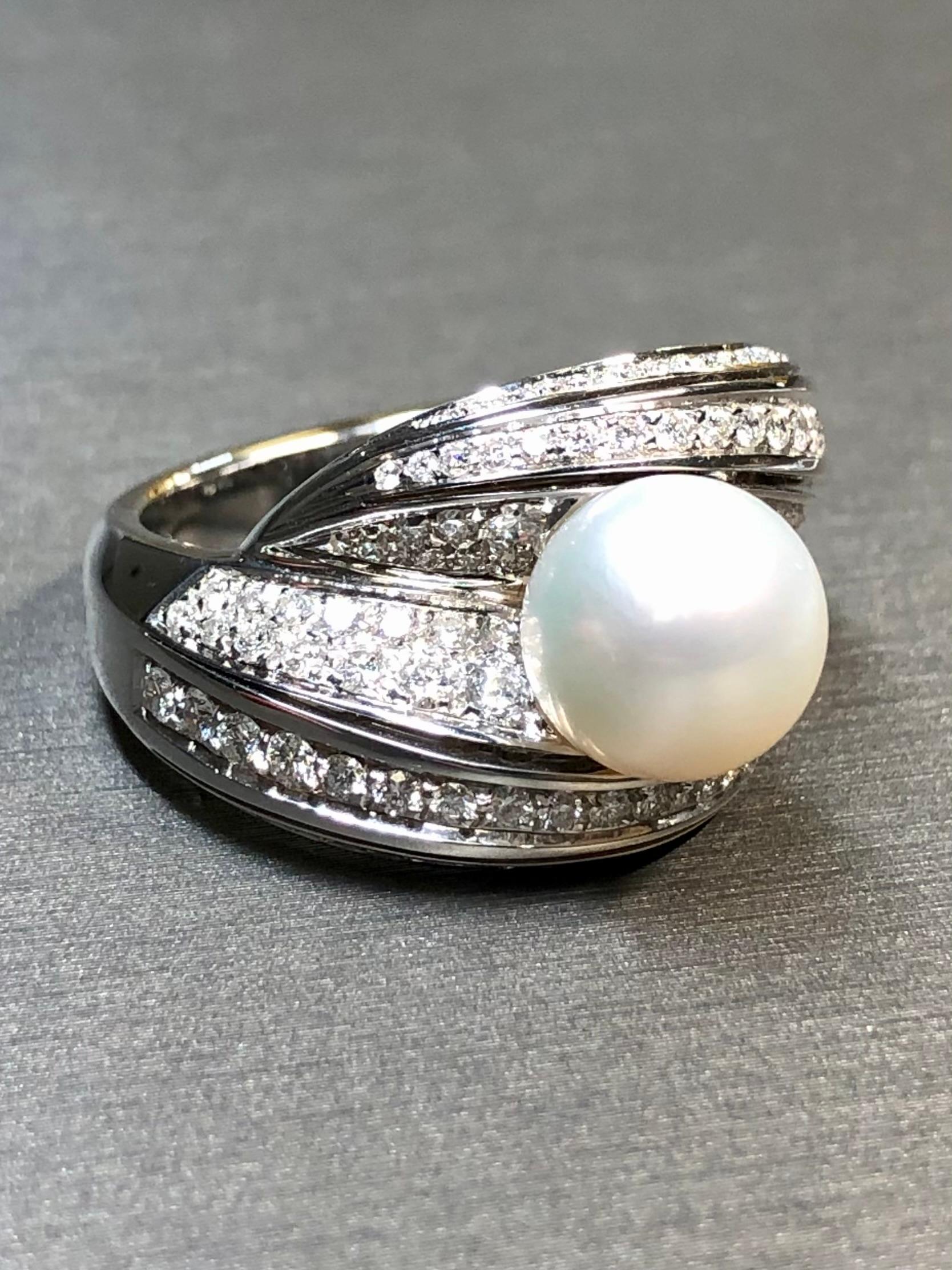 An elegant bypass ring by MIKAWA for Damiani done in 18K white gold and set with approximately 2.40ctw in F-G color Vs+ clarity round diamonds and centered by a 9.20mm cultured pearl. Ring is complete with original store sticker and