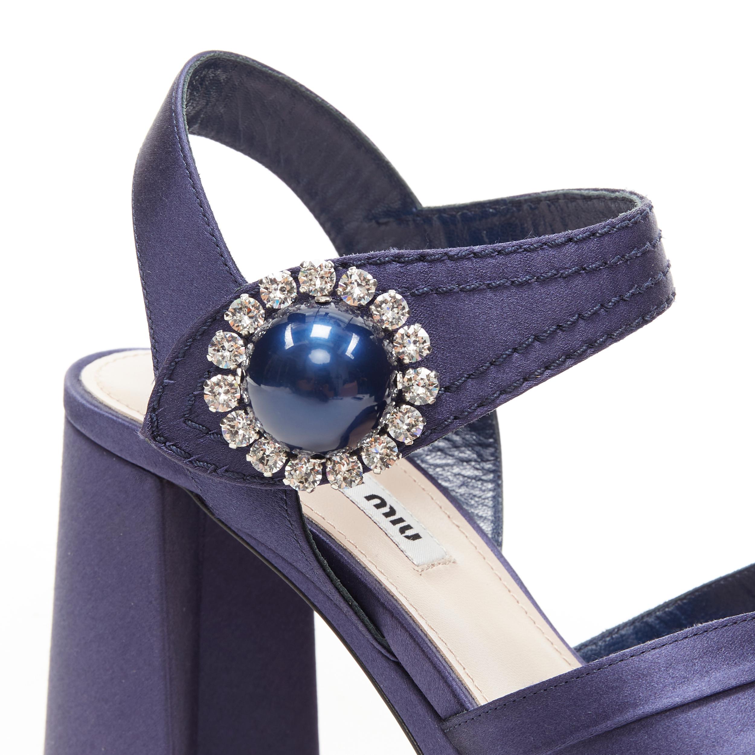 new MIU MIU navy blue satin crystal pearl platform chunky heel sandals EU38.5 
Reference: TGAS/B00647 
Brand: Miu Miu 
Designer: Miuccia Prada 
Model: Crystal embellished navy platform heels 
Material: Silk 
Color: Navy Pattern: Solid 
Closure: