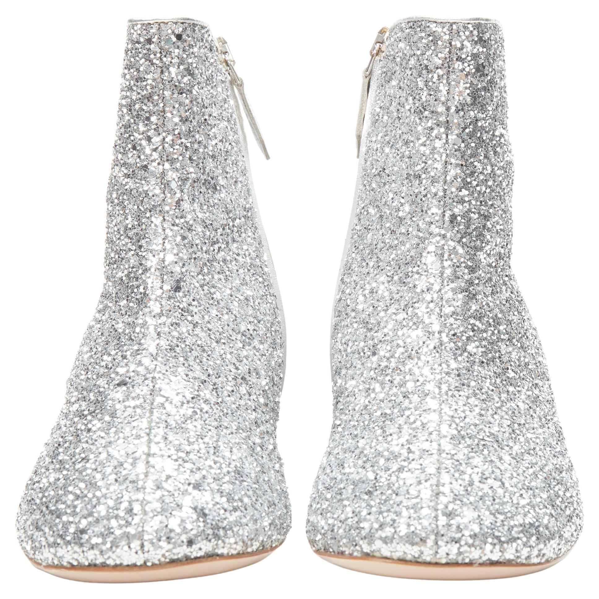 new MIU MIU silver glitter large rhinestone crystal heel ankle boots EU37
Brand: Miu Miu
Designer: Miuccia Prada
Material: Leather
Color: Silver
Pattern: Solid
Closure: Zip
Extra Detail: Round toe ankle bootie. Silver course glitter covered leather.