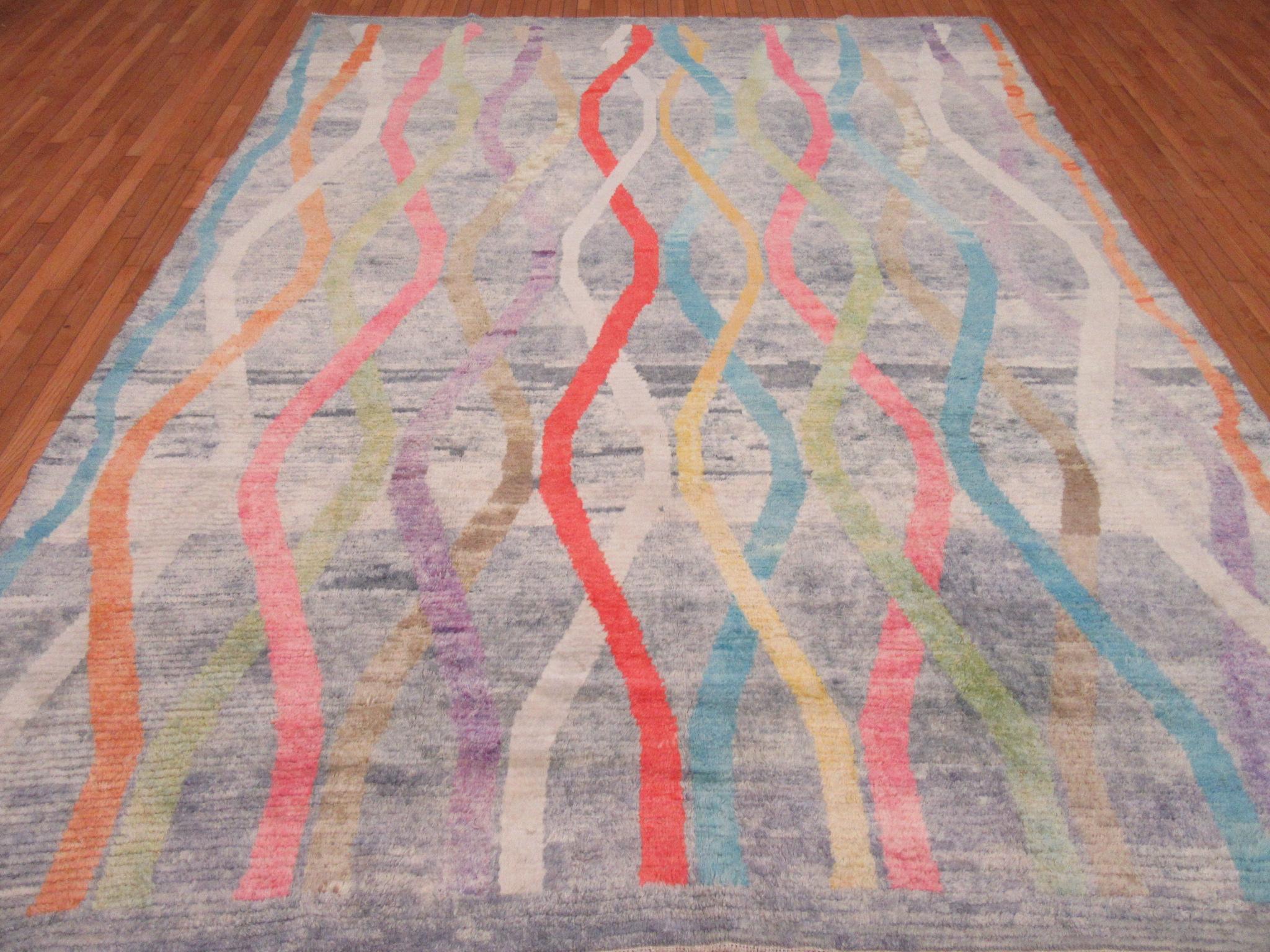 This is a new hand knotted rug from Turkey. It has a larger knotted Oushak weave and a modern ribbon design in rich colors. It is a large and fun rug for any room. It is made with fine Turkish wool and measures 9' 3'' x 12'.